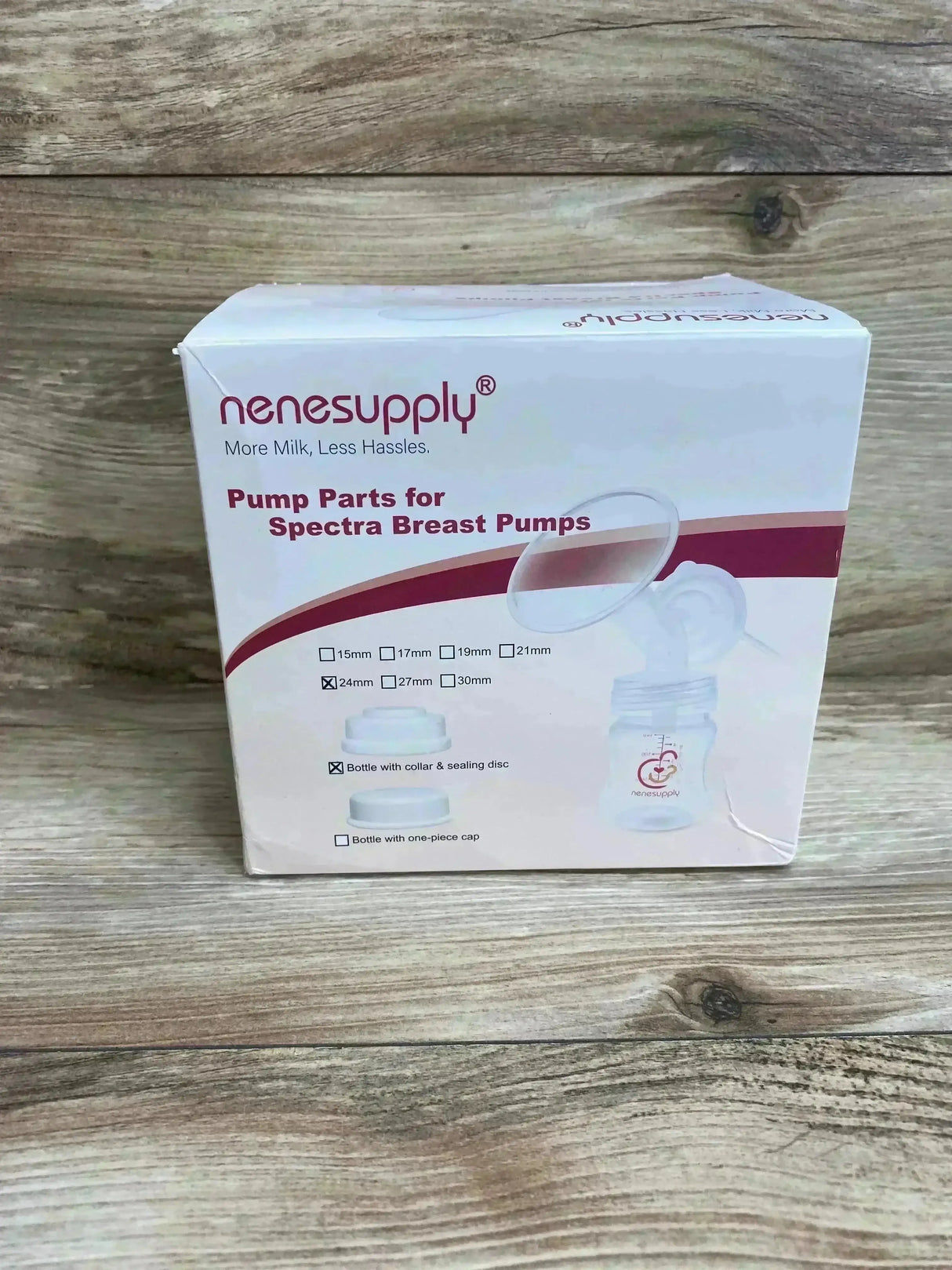Front view of Nenesupply pump parts box showcasing Spectra-compatible 24mm parts with bottle and collar illustrations on wood tabletop