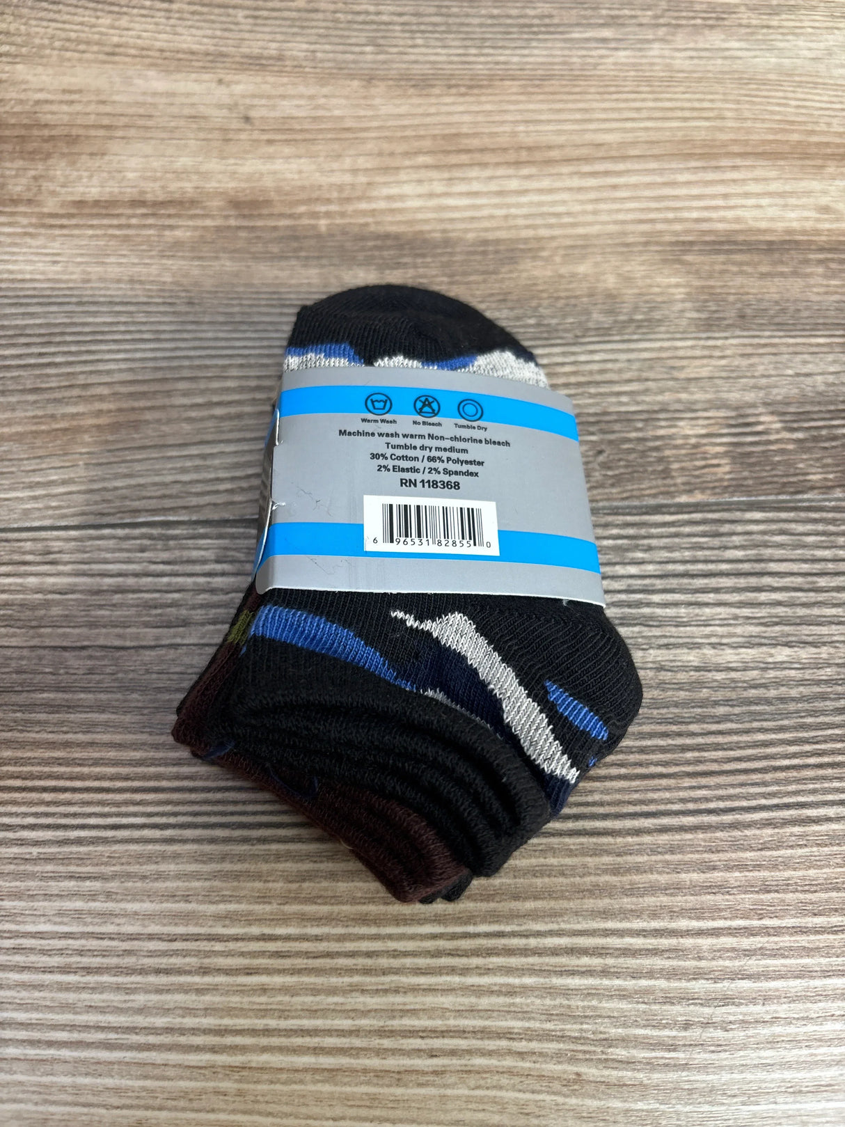 Pack of folded black patterned socks with blue and white details on wooden surface