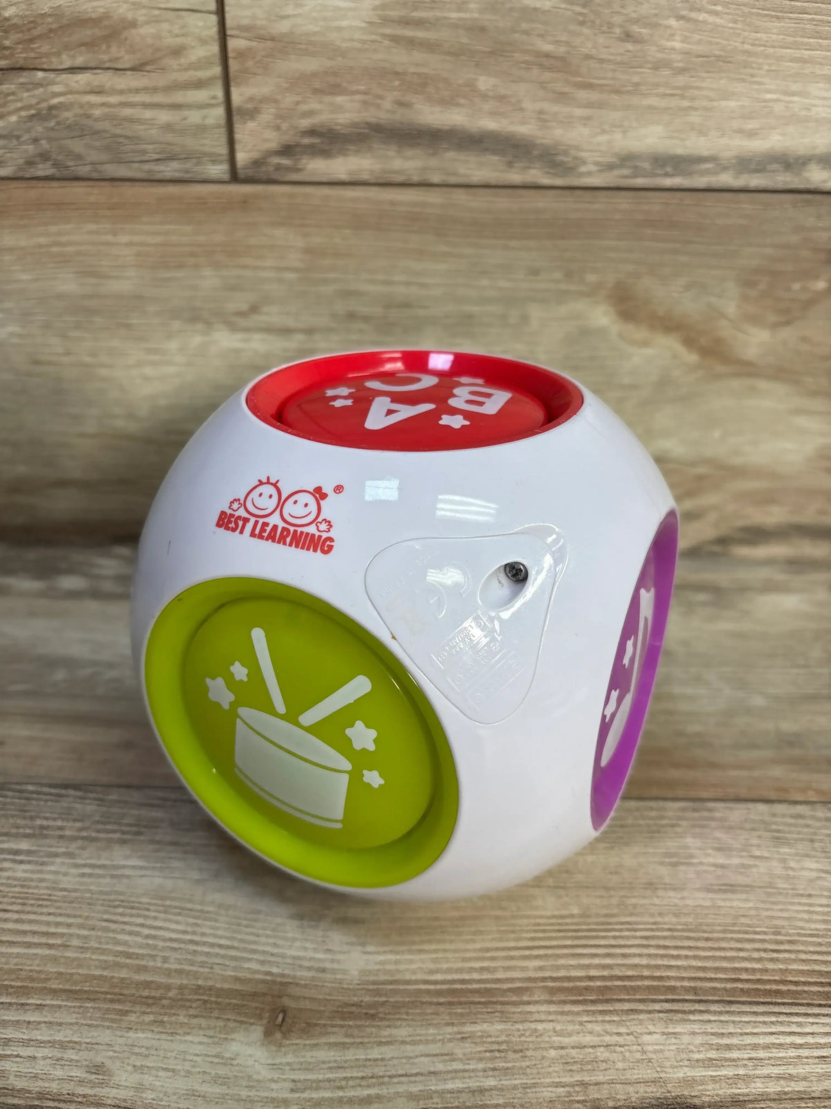 Front and top view of Best Learning Learning Cube showcasing colorful activity buttons with a wood tabletop background