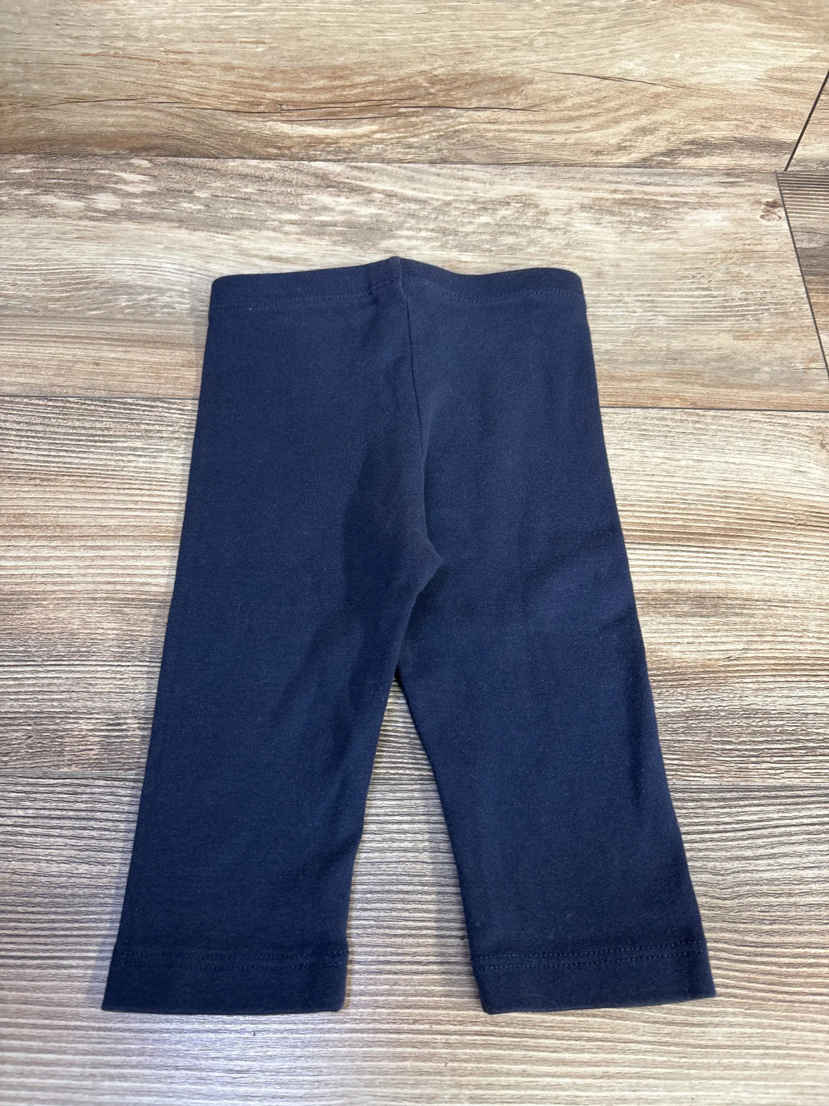 Front view of City Threads long bike shorts in navy, size 3T, showcasing the elastic waistband and long legs on a wood-grain background