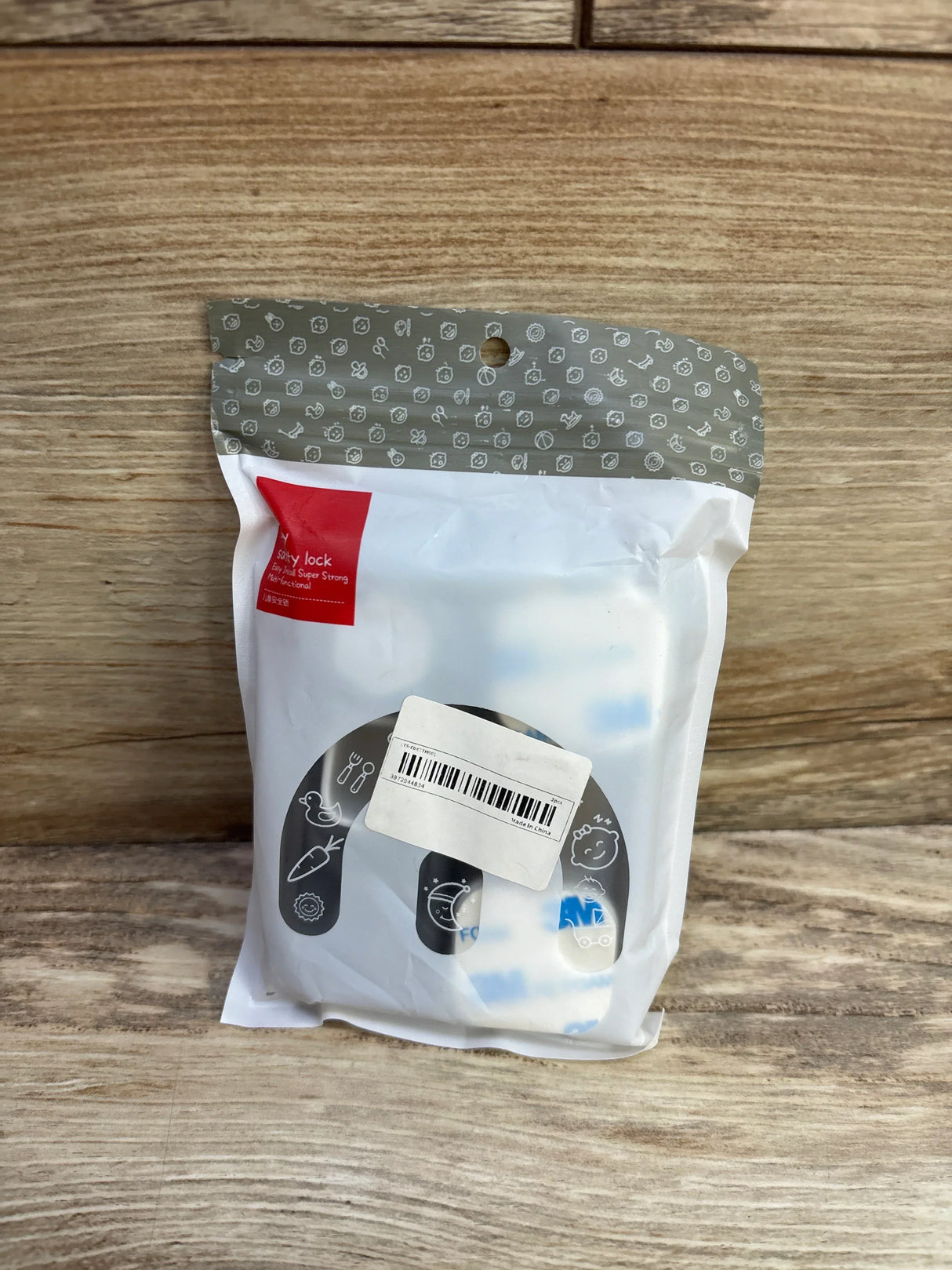 Front view of NiHome child-proof refrigerator locks in sealed white package showing adhesive strap locks and release key on wooden surface