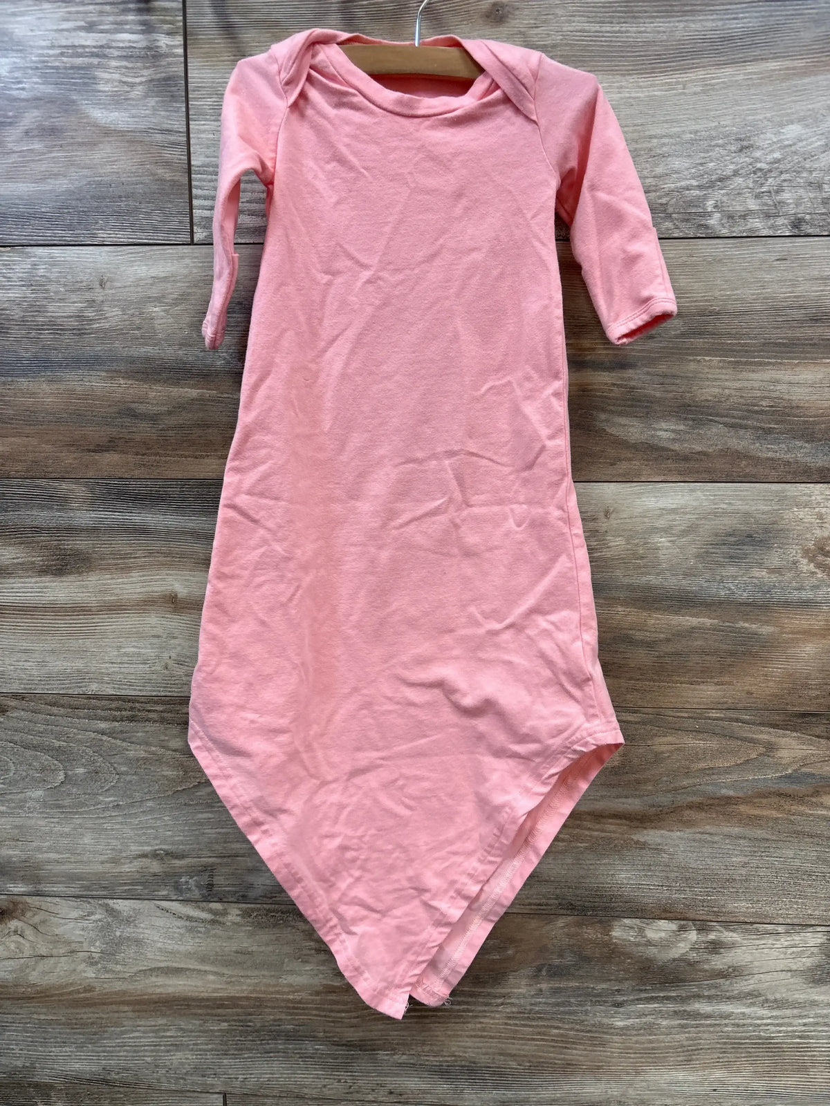 Front view of Baby Noah knotted gown in pink showing long sleeves and knotted bottom, size 3 months, on wooden floor