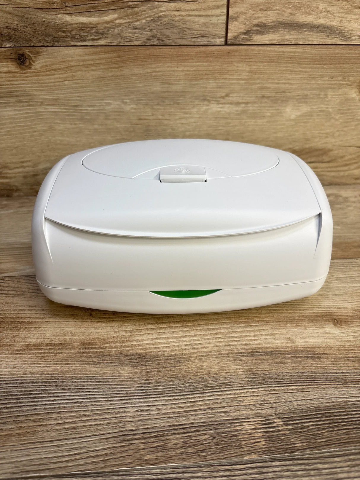 Front view of Prince Lionheart Ultimate Wipes Warmer showing white case, flip-top lid with push release and green indicator on wood background