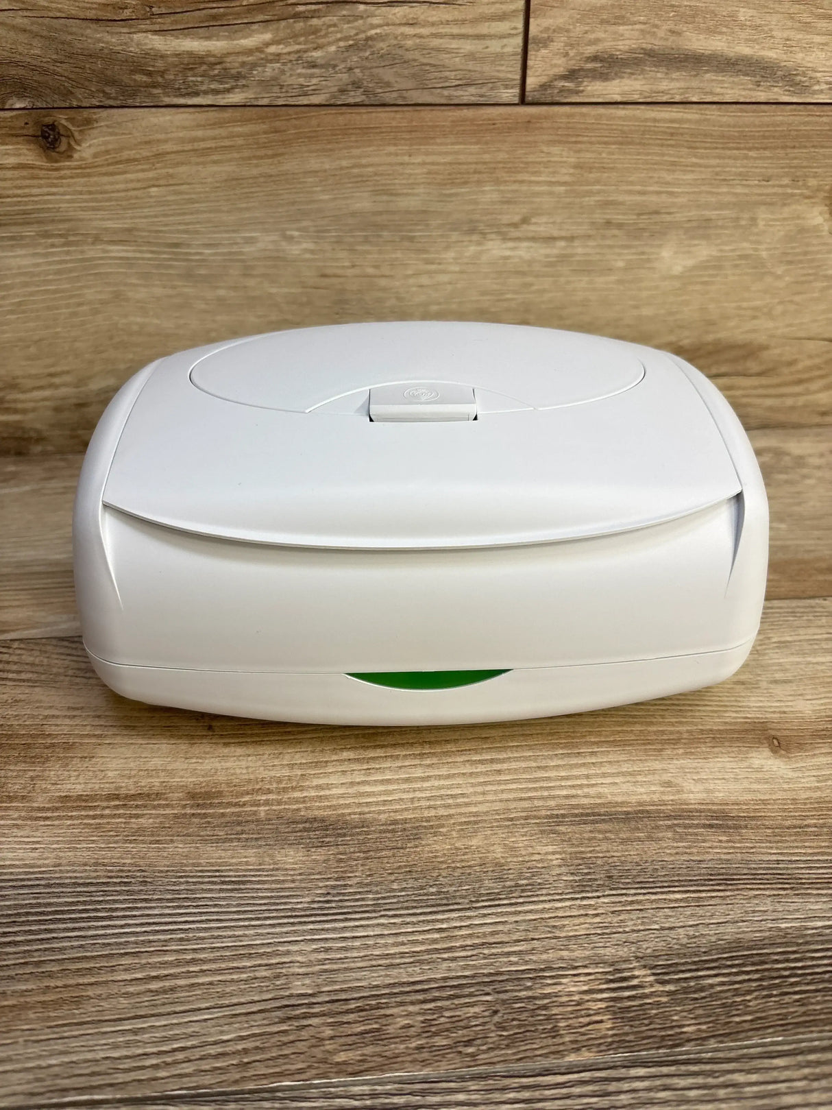 Front view of Prince Lionheart Ultimate Wipes Warmer showing white case, flip-top lid with push release and green indicator on wood background