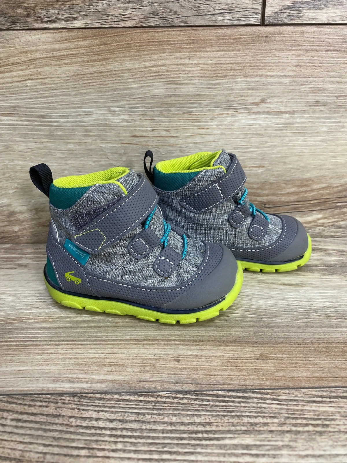Three-quarter view of See Kai Run Sam II waterproof boots in grey with neon green sole and lining, Velcro closure