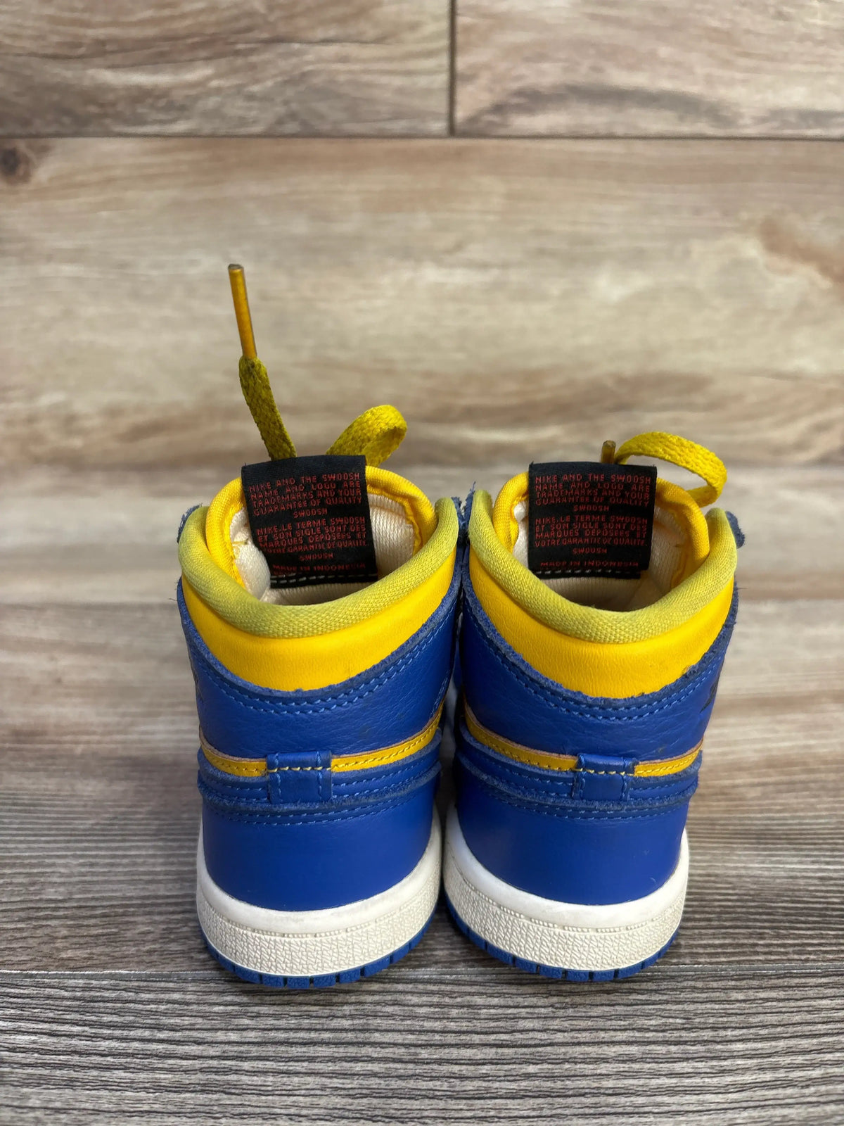Rear view of Air Jordan 1 Retro High OG TD Reverse Laney sneakers showing blue and yellow leather uppers