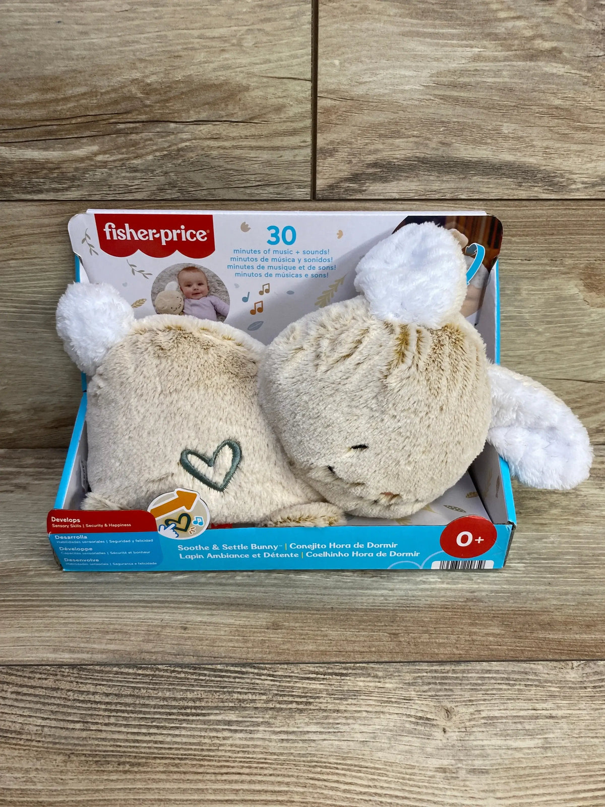 Front view of Fisher-Price Soothe and Settle Bunny showing beige rabbit with heart detail and white ears on wood background