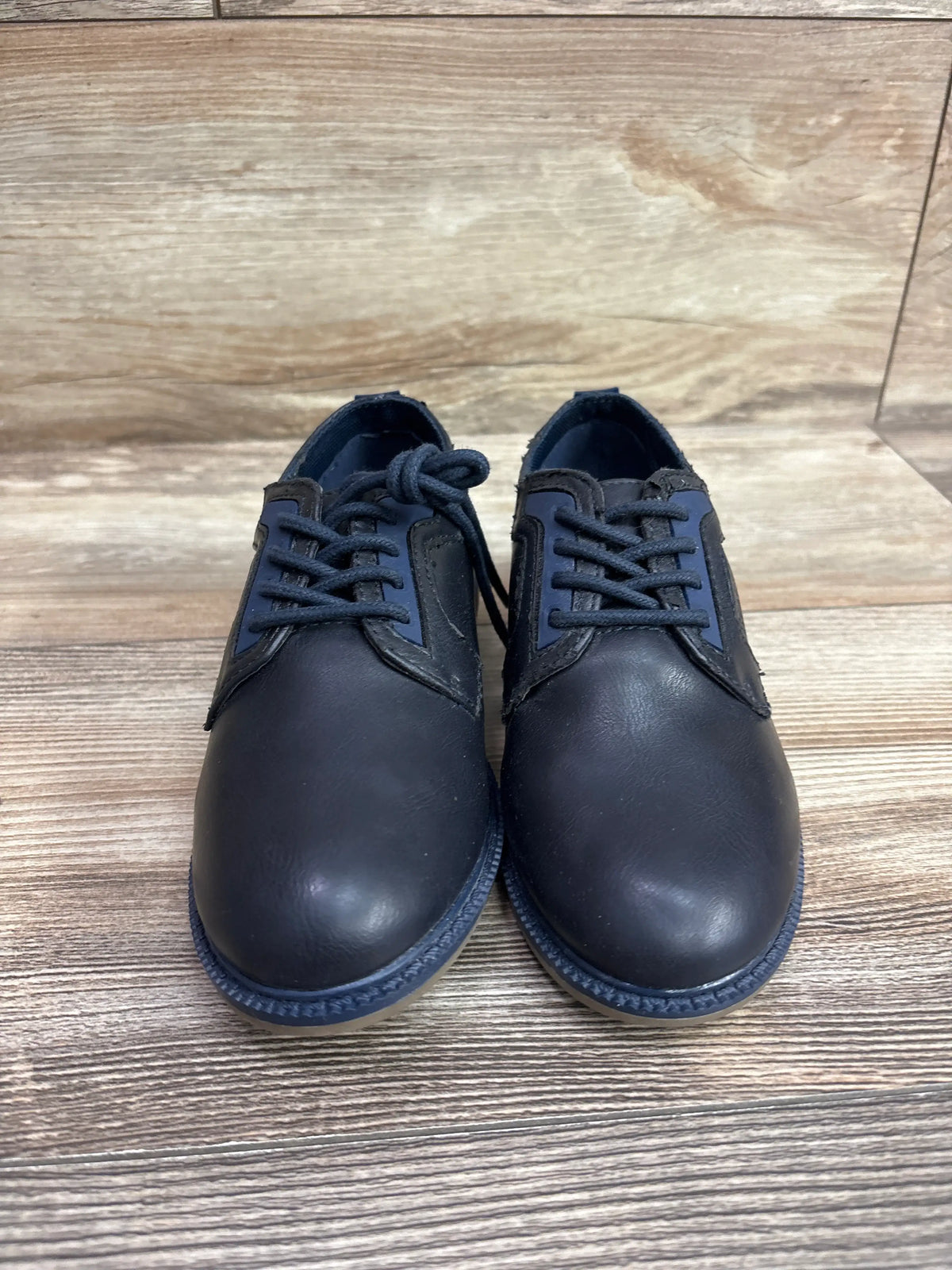 Front view of Reaction by Kenneth Cole navy Oxford dress shoes in size 11/12C showcasing lace-up fronts on a wood-look floor