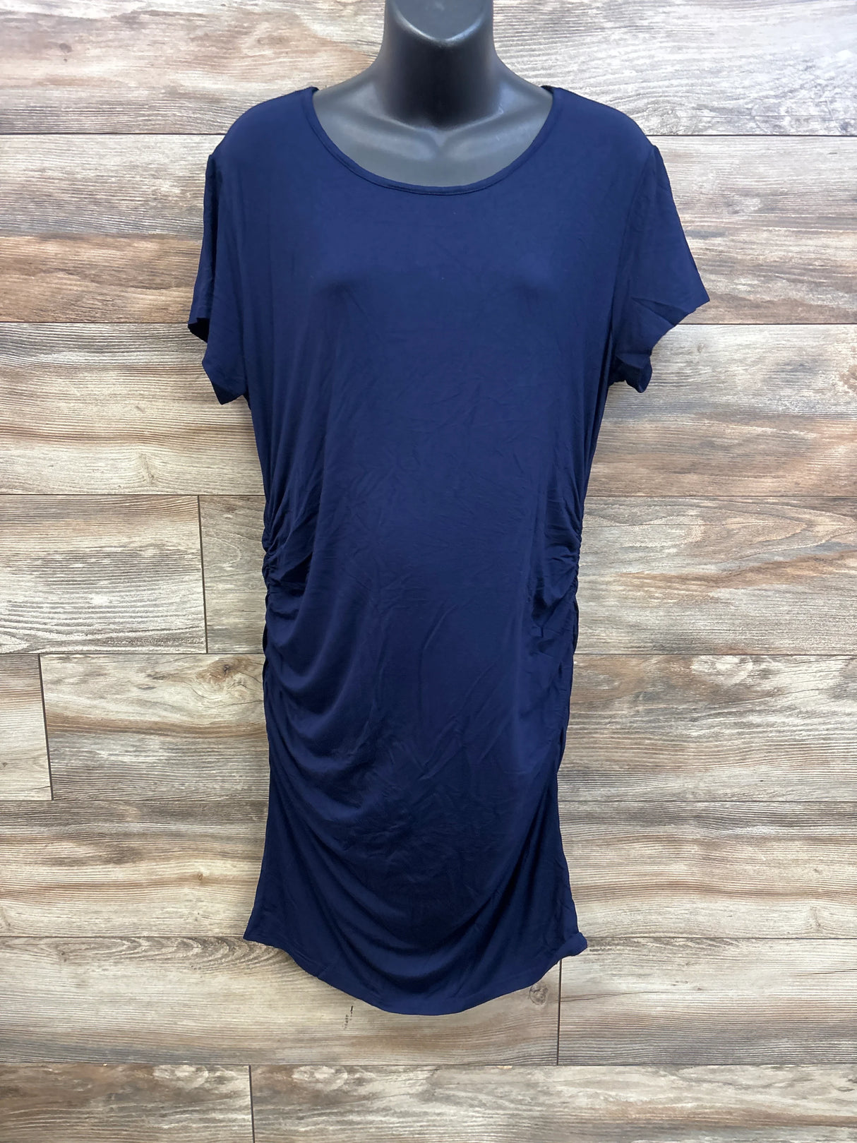 Front of Smallshow maternity ruched navy bodycon dress showing side ruching and short sleeves against wood background
