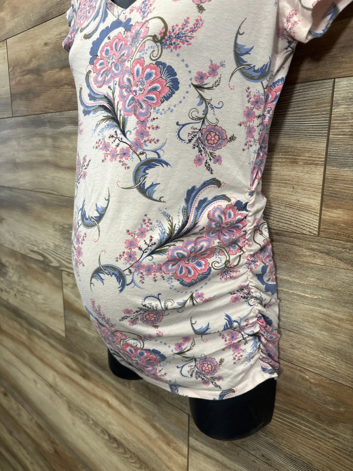 Floral print maternity top with ruched sides displayed on mannequin