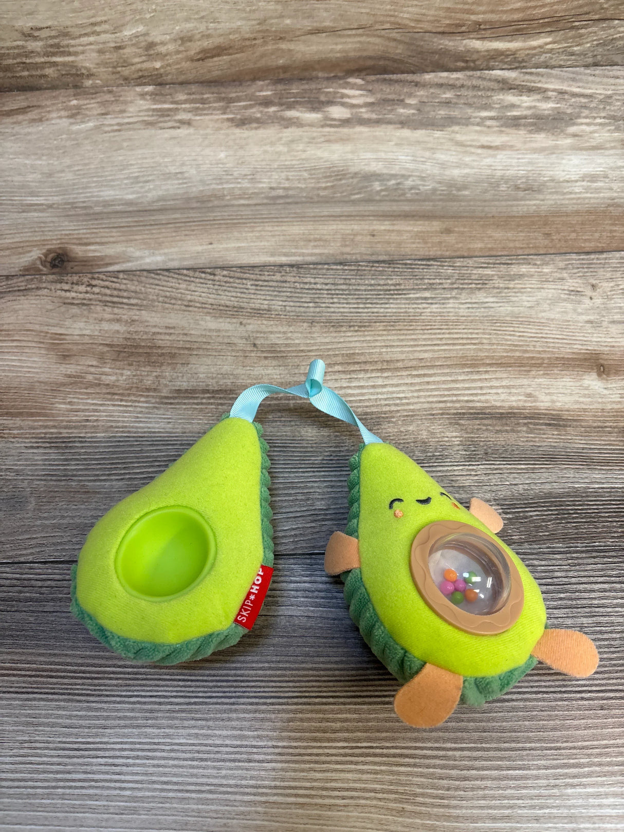Adorable avocado-shaped baby teether with rattle, soft plush design for infant sensory play