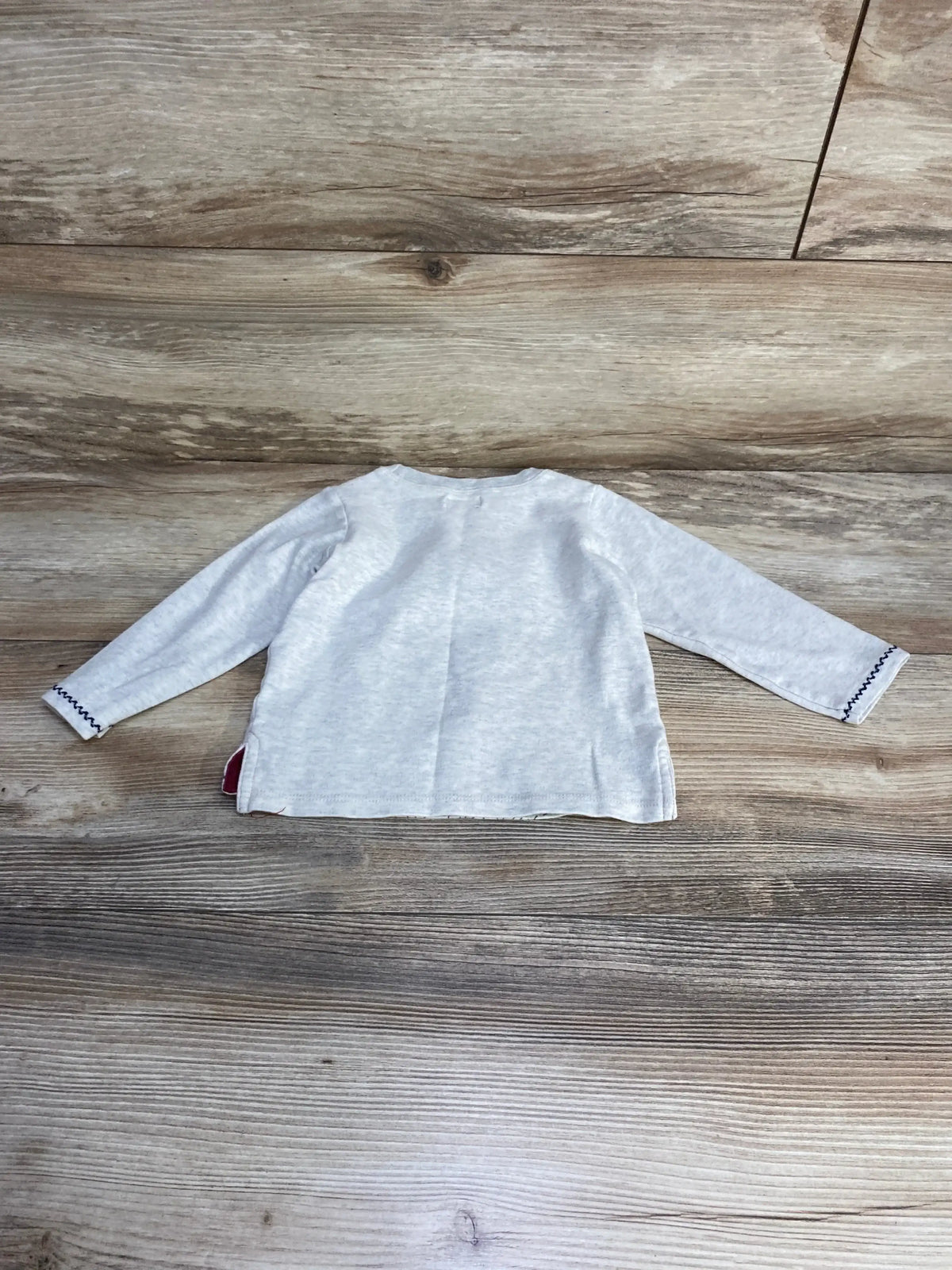 Back view of Mud Pie bear shirt, grey long-sleeve 12–18M showing navy zigzag cuffs and red-lined side slit on wood