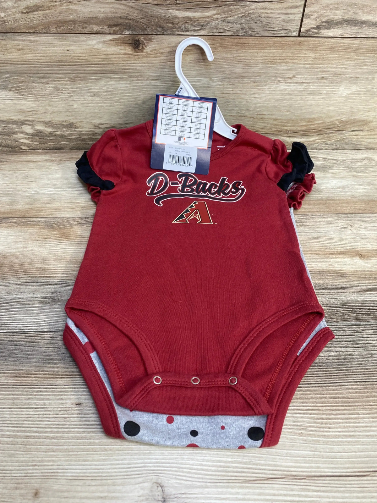 Top-down view of Arizona Diamondbacks 2-piece onesie set: red D-Backs bodysuit over grey dotted bodysuit on wood