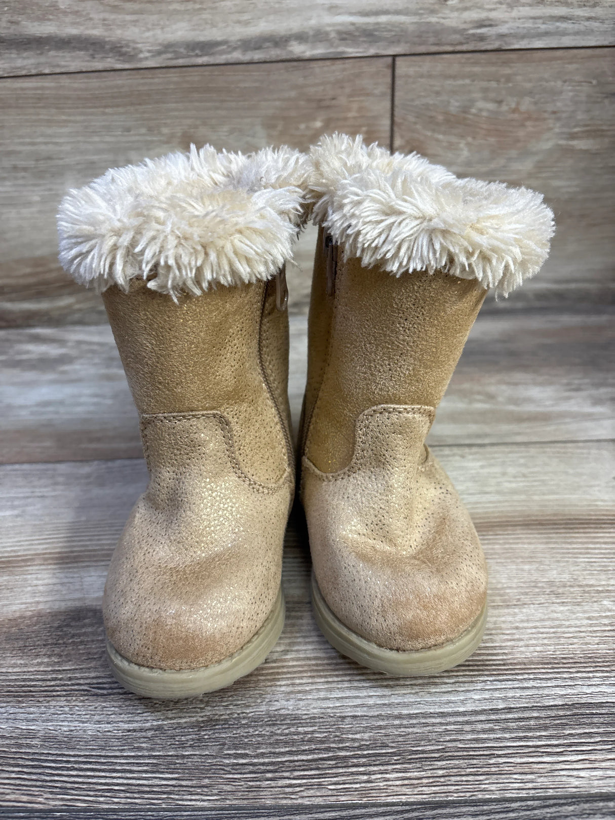 Front view of Cat and Jack toddler winter boots showing cognac suede, cream faux-fur cuff, on wooden floor