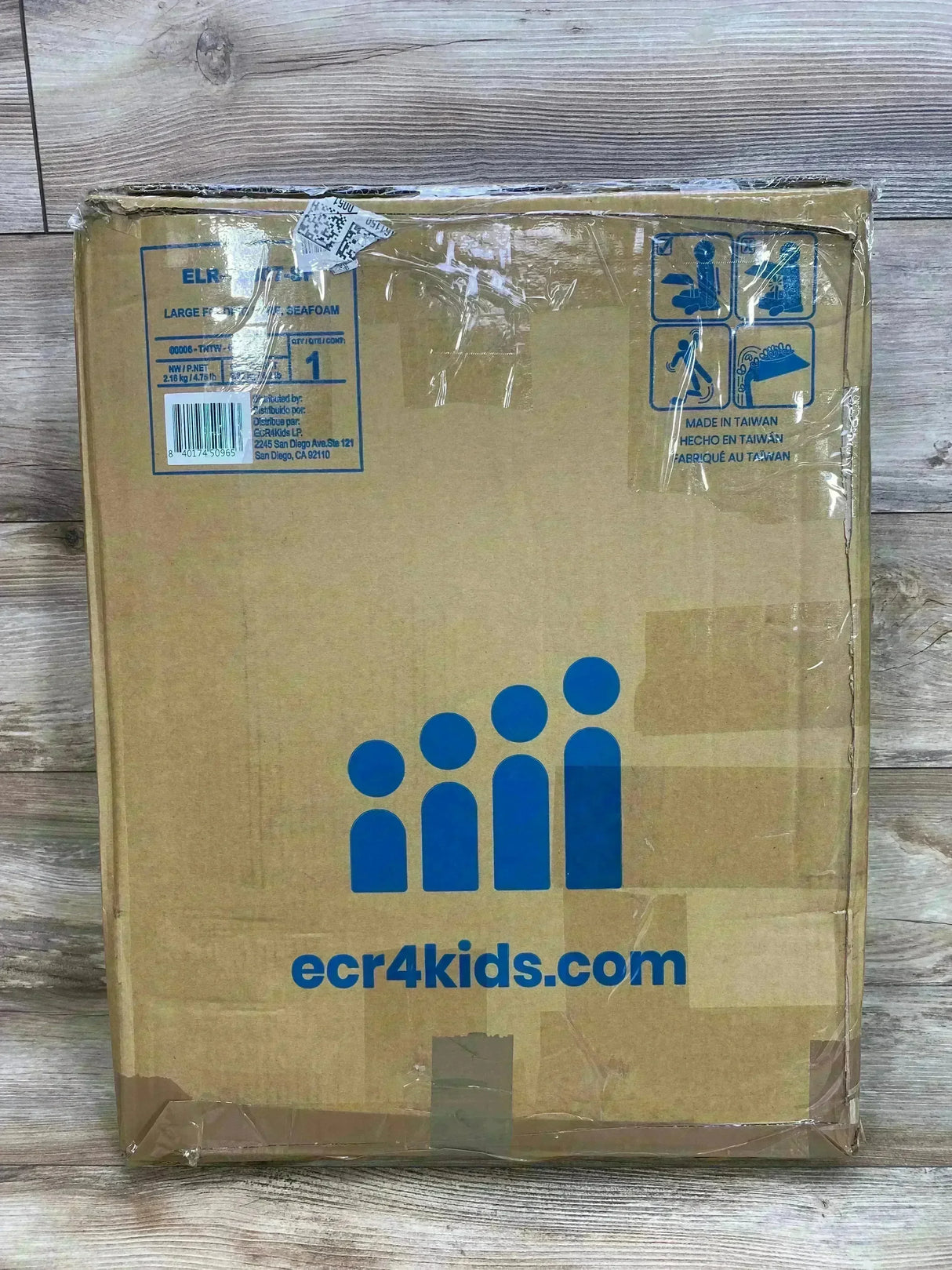 Front view of The Surf folding portable lap desk box showing brand logo and seafoam color label, taped packaging on wood floor