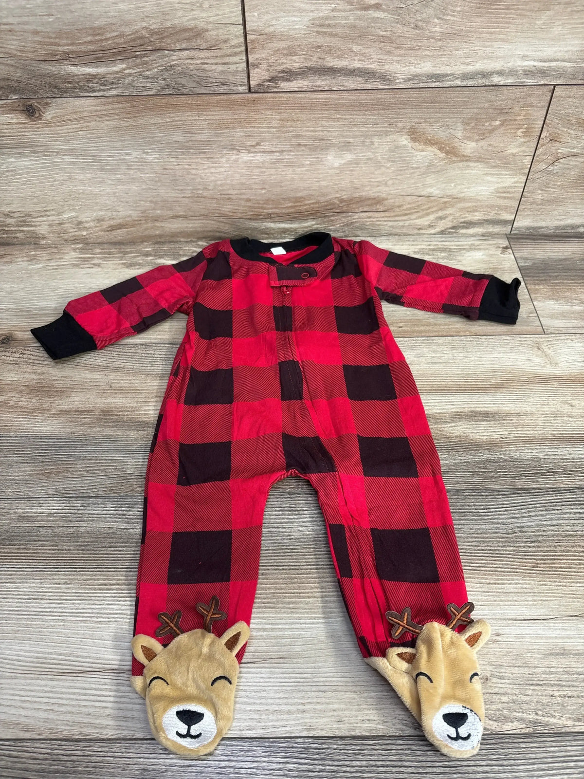 Red plaid baby sleeper with reindeer footies on wood floor, long sleeves, cute holiday outfit
