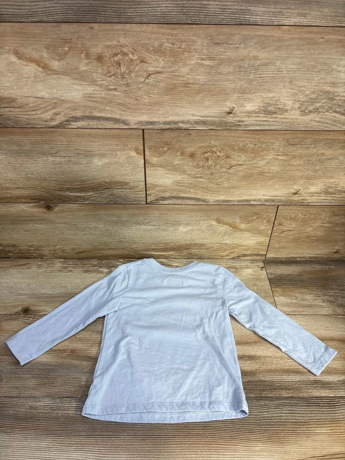 Back view of Cat & Jack blue waffle shirt in size 3T showcasing long sleeves on a wood plank background