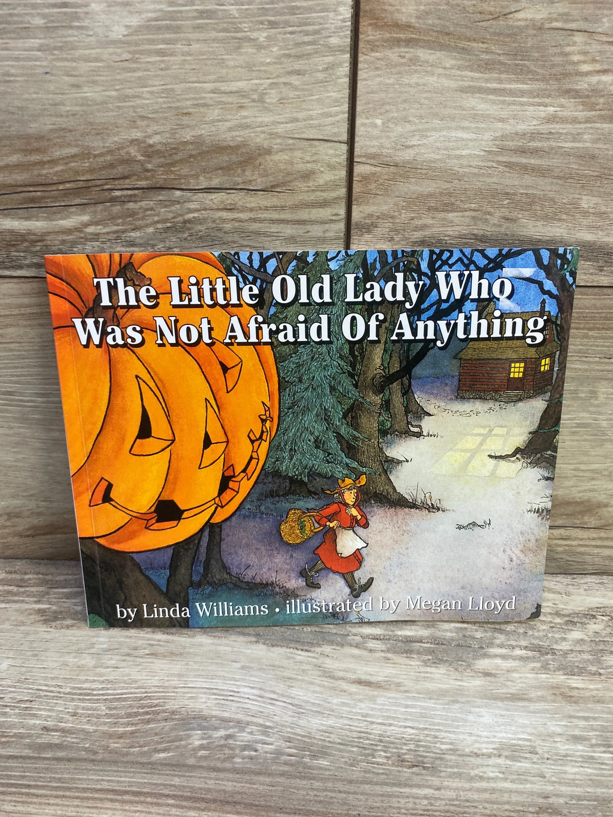 Front cover of paperback The Little Old Lady Who Was Not Afraid Of Anything showing jack-o-lanterns and a woman in red