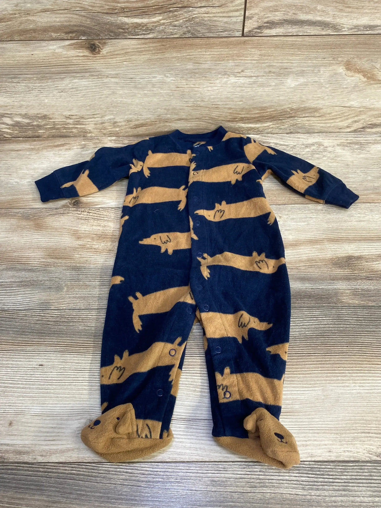 Flat lay of Carter's navy and tan dog-print footed sleeper size 6M with snap-front and embroidered-face footies on light wood