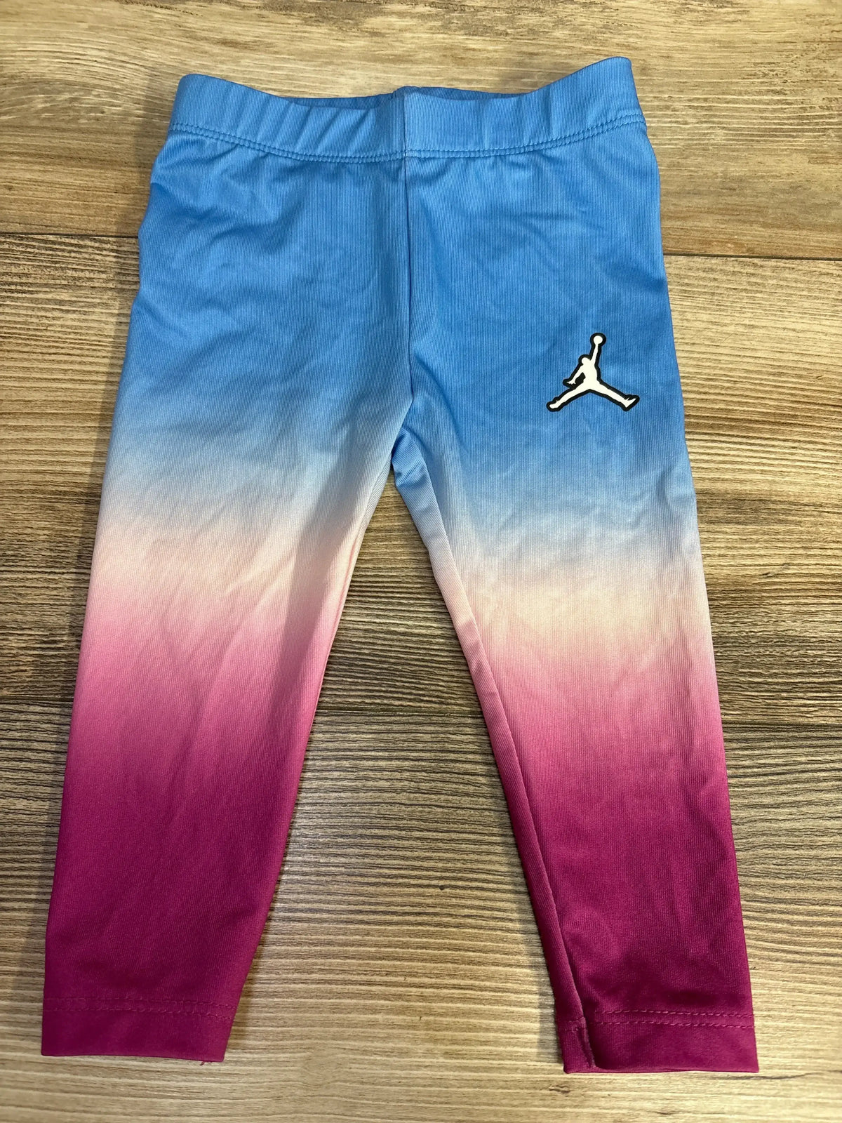 Kids' Jordan leggings with blue to pink ombre design and Jumpman logo on wooden floor