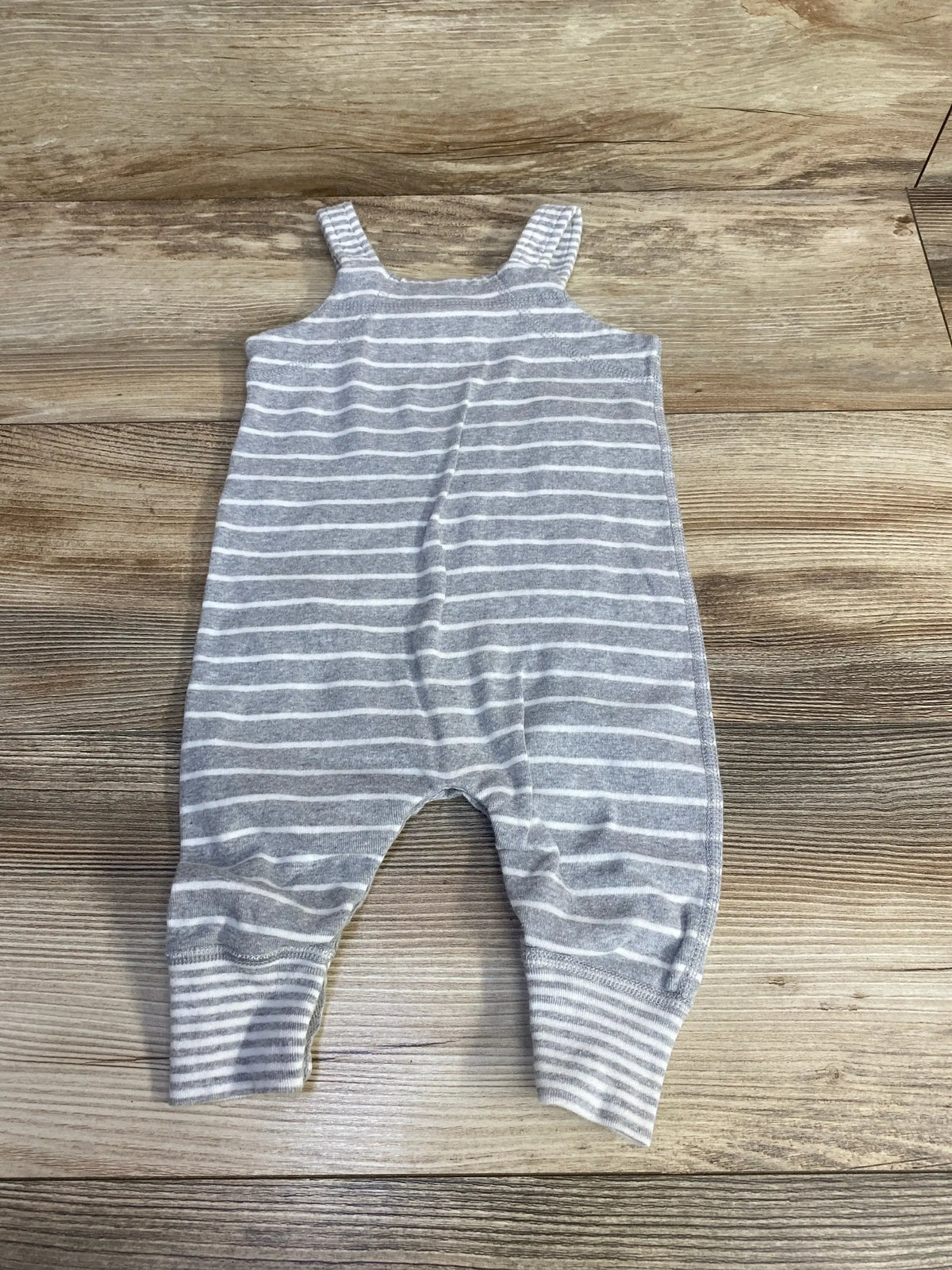Flat lay of Hanna Andersson Organic Striped Shortall in grey and white stripes with ribbed cuffs sz 3-6m on wood plank floor