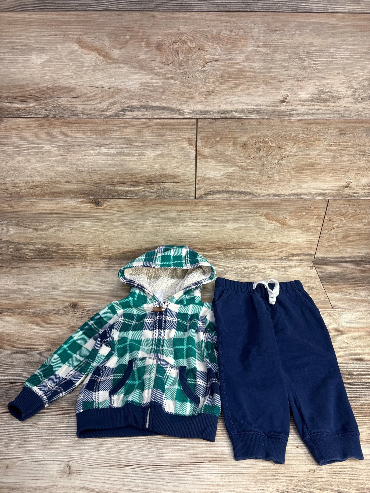Plaid green and navy hooded jacket with navy sweatpants on wood floor