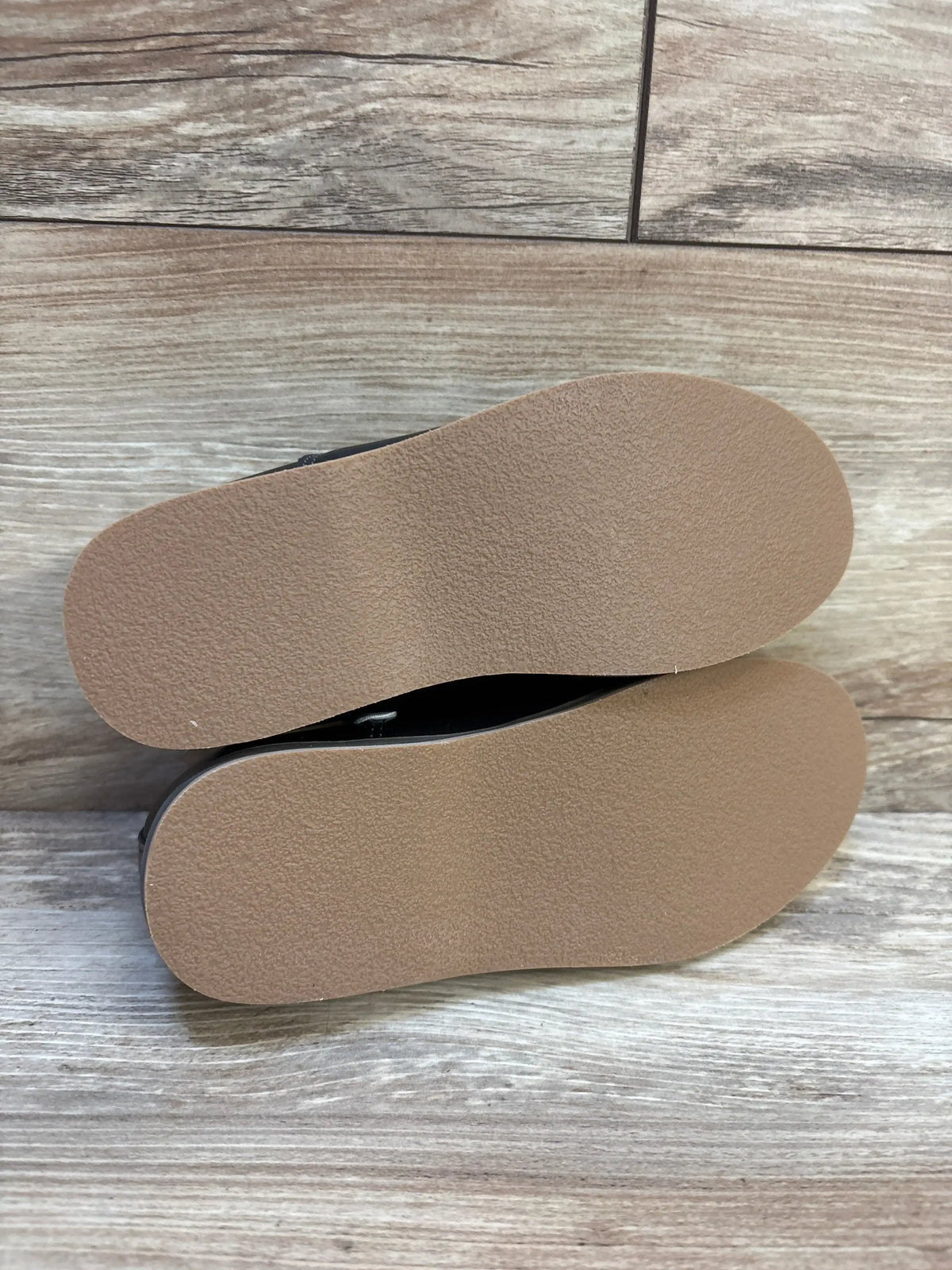 Bottom view of Cat & Jack Neal black toddler loafers (size 12C) showcasing clean tan rubber soles on wood floor background