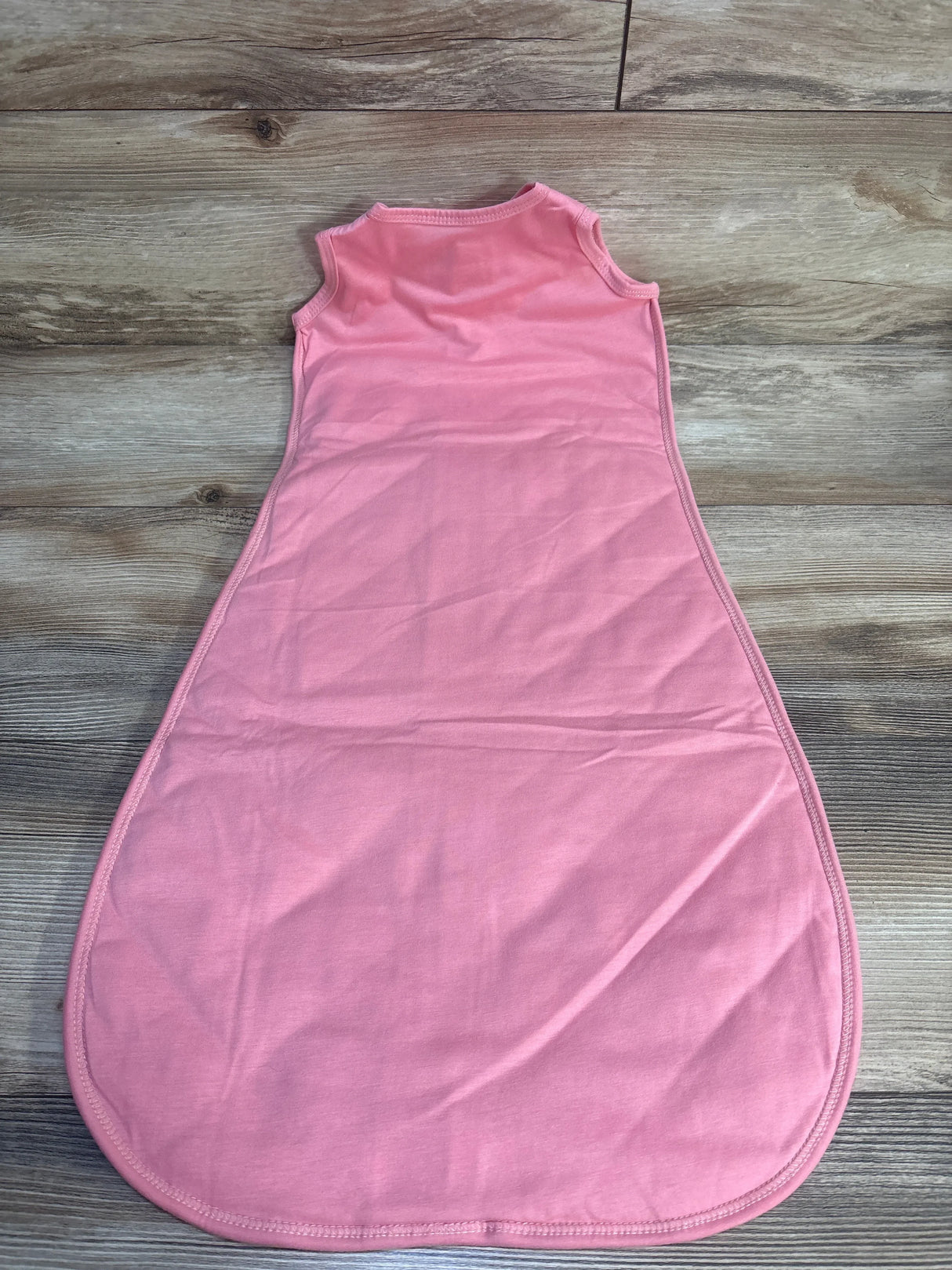 Sleeveless pink baby sleep sack on wood background, gently used kids clothing