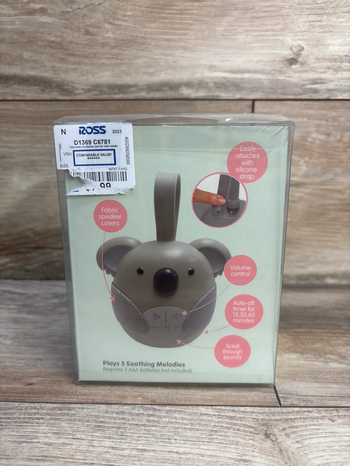 Front view of koala sound machine in retail box showcasing silicone hanging strap and fabric speaker covers on wooden background