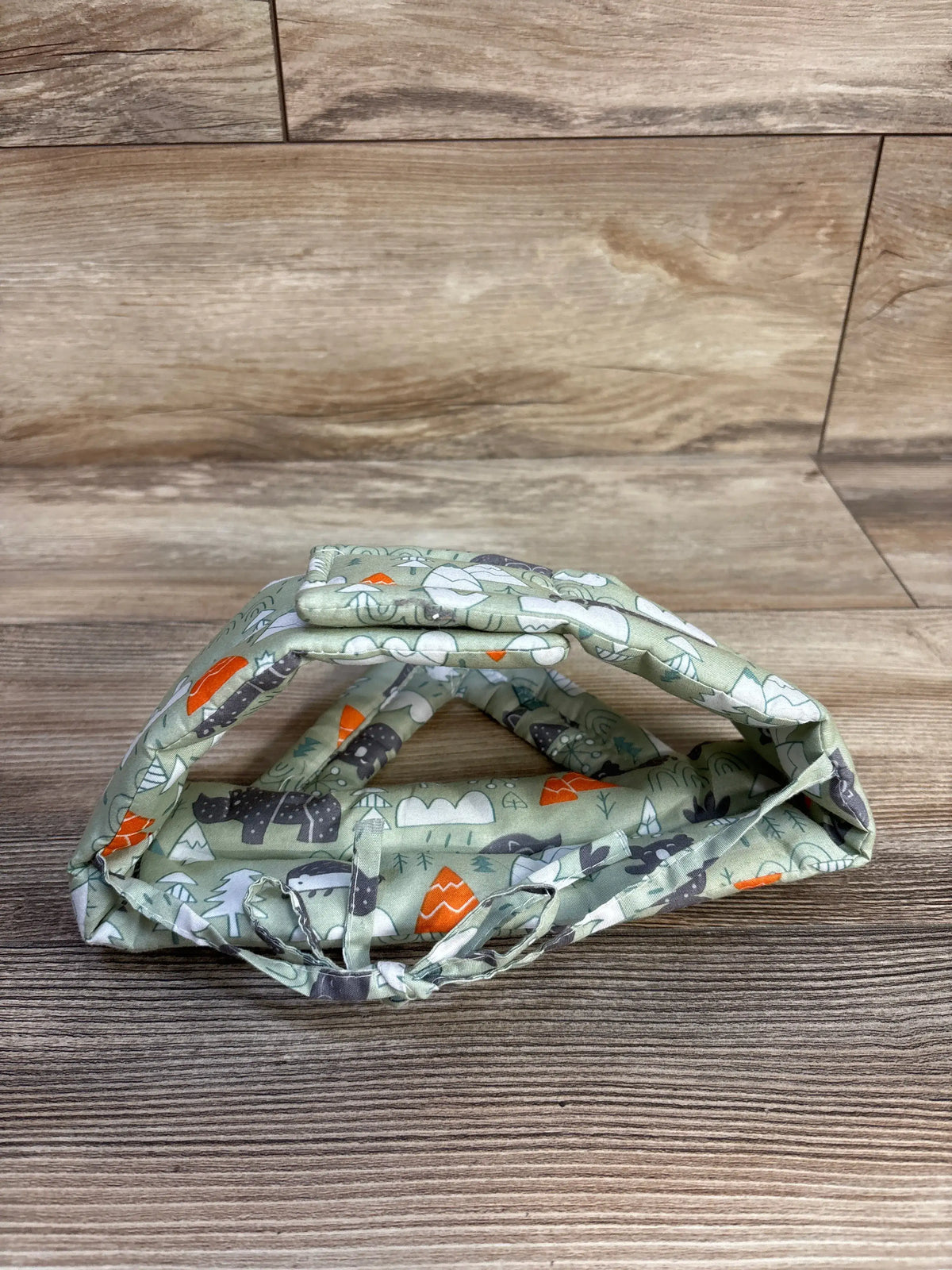 Green IULONEE baby head protection helmet with nature pattern on a wooden surface