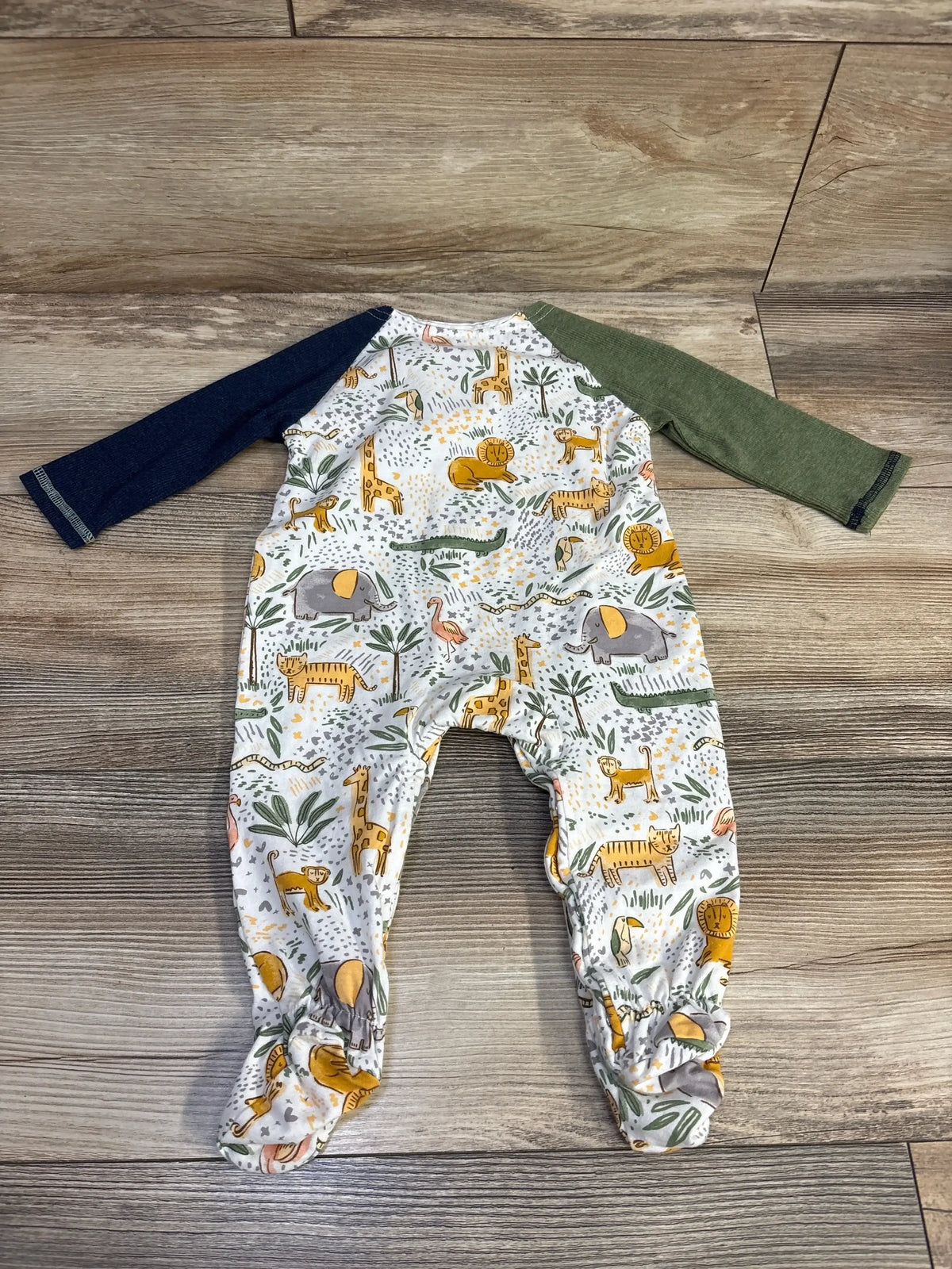 Baby romper with jungle animal print and mismatched long sleeves on wooden floor