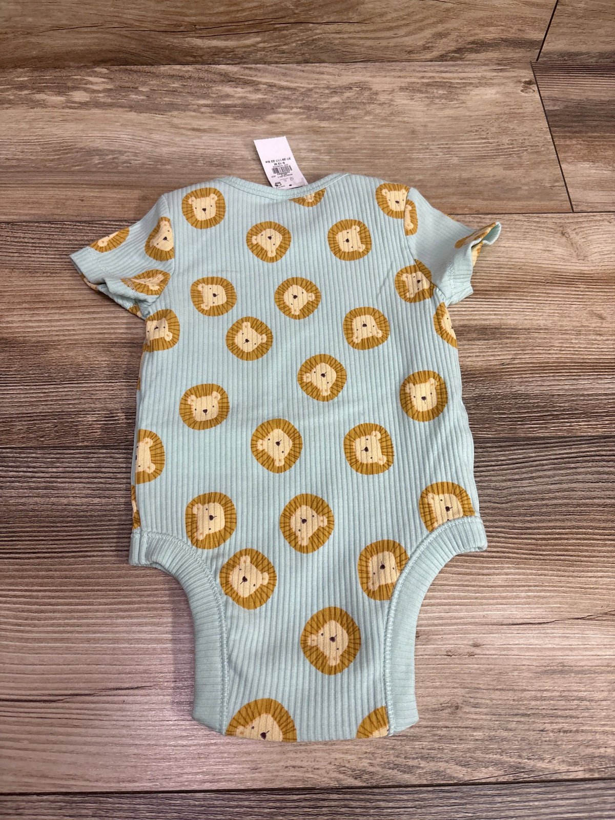 Front view of a blue Old Navy rib-knit bodysuit showcasing an allover lion print and short sleeves on a wood background