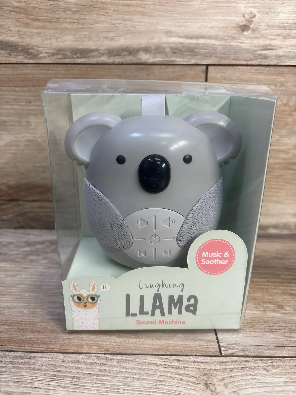 Front view of Laughing Llama Koala sound machine in clear box showing control buttons, fabric speakers, and packaging text