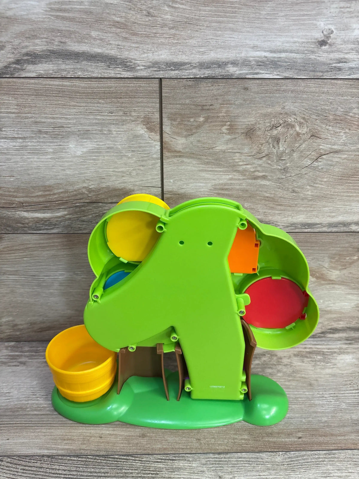 Back view of Learning Resources Hide & Seek Learning Treehouse showing colorful apples behind openings and yellow chute