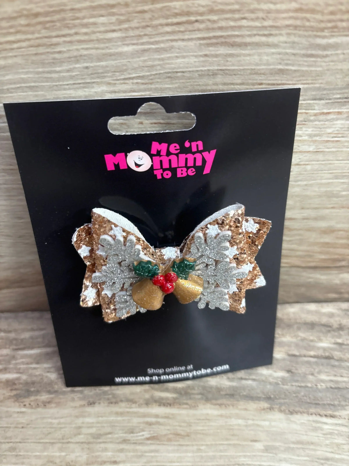 Glittery gold and silver snowflake hair bow with holly berries, perfect for kids' holiday outfits.
