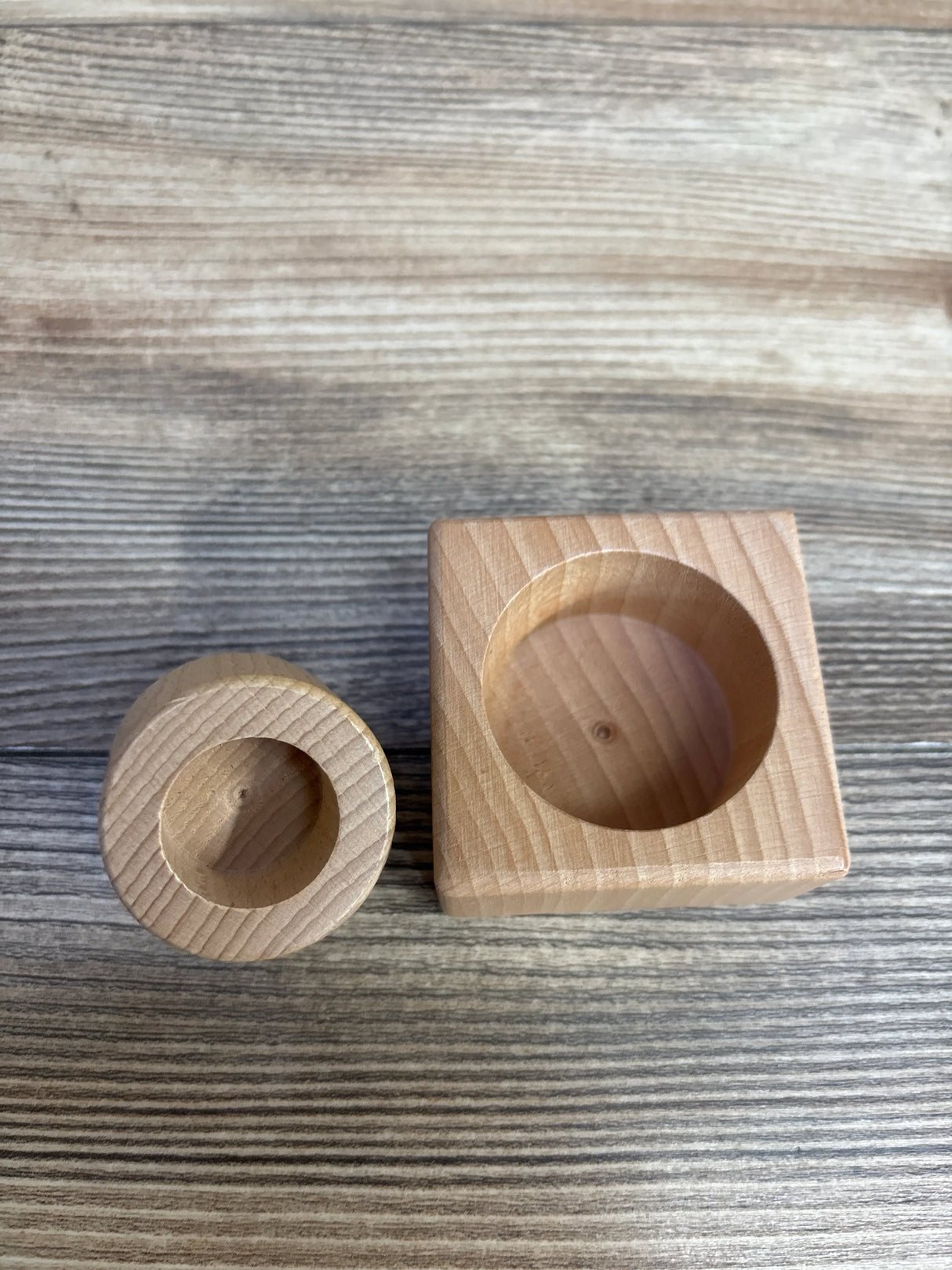 Two wooden Montessori sorting cups on a rustic wood background