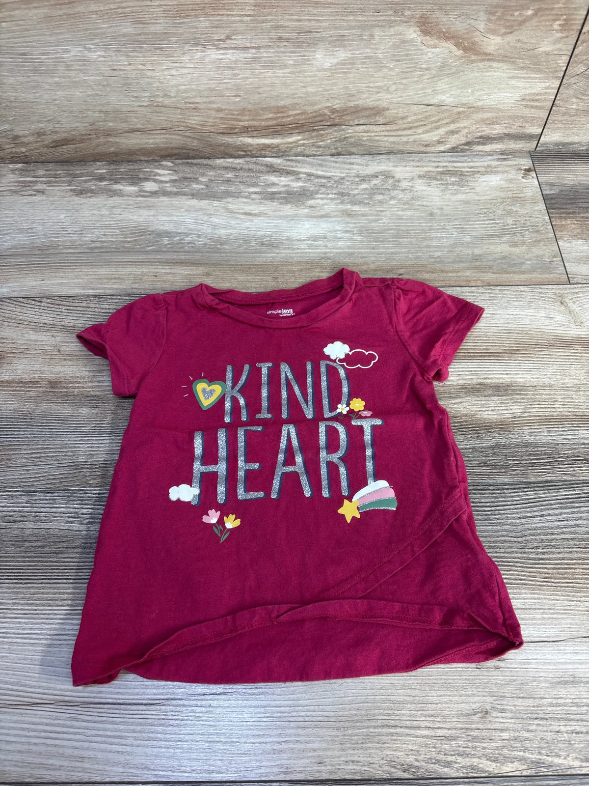 Front view of Simple Joys by Carter’s red toddler shirt showcasing a KIND HEART graphic on a wood floor