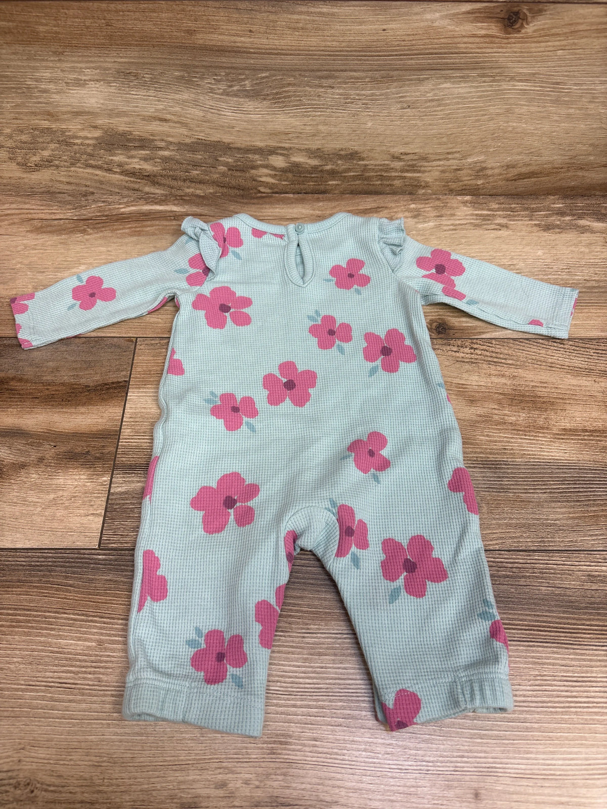 Front view of Just One You blue waffle knit coverall showcasing pink floral print and long sleeves on a wood floor