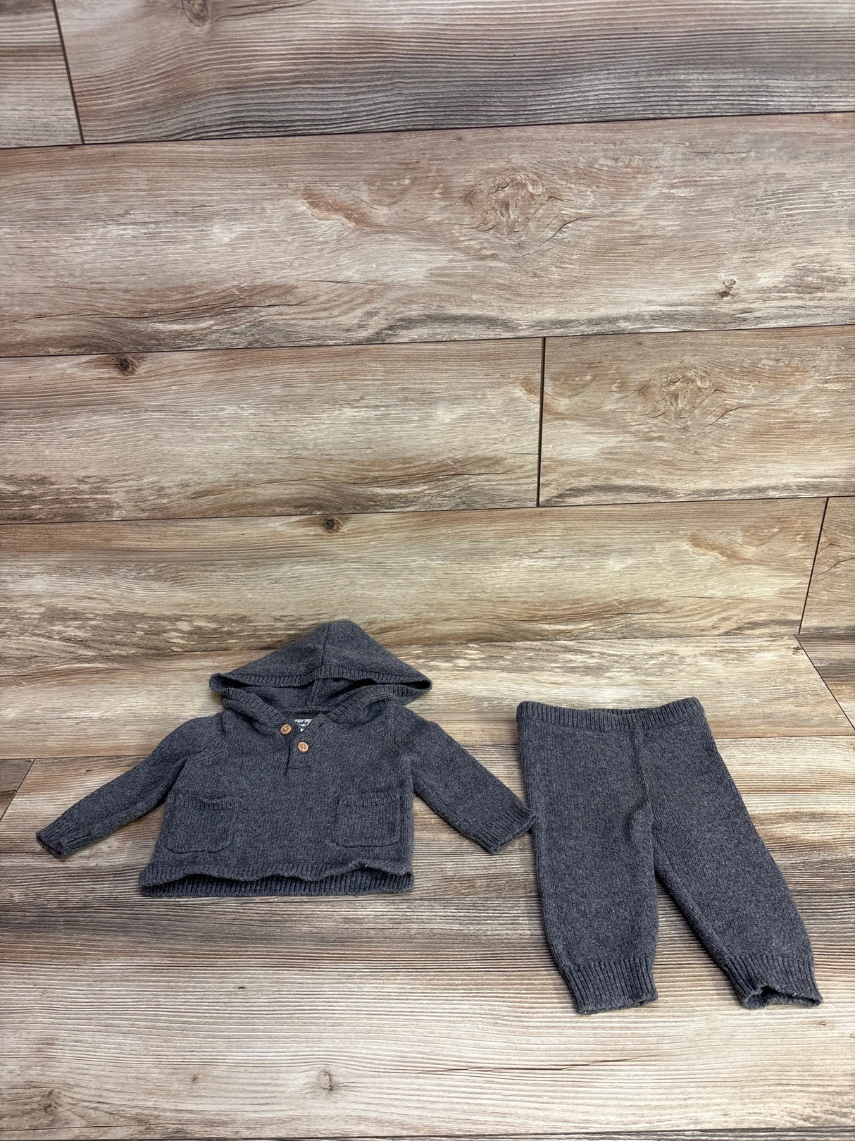 Gray knit baby hoodie and pants set on wood background, cozy kids clothing