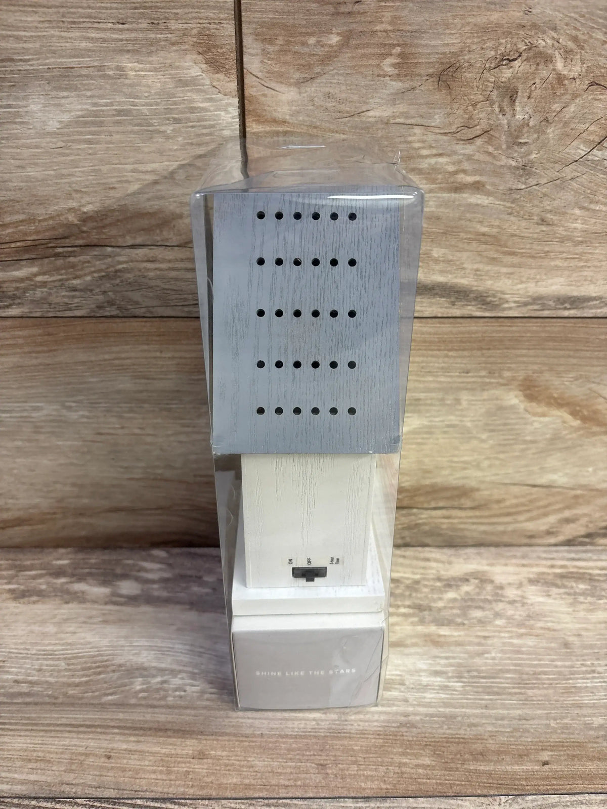 Front of Cloud Island LED birdhouse night light showing switch and Shine Like the Stars text in clear packaging on wood