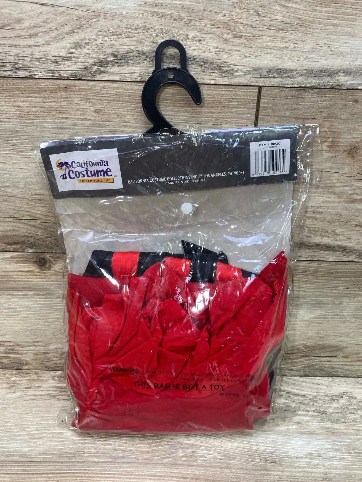Front view of California Costume Hip Punk Pirate Girl Costume sz 8-10 in red and black clear packaging on a wood surface
