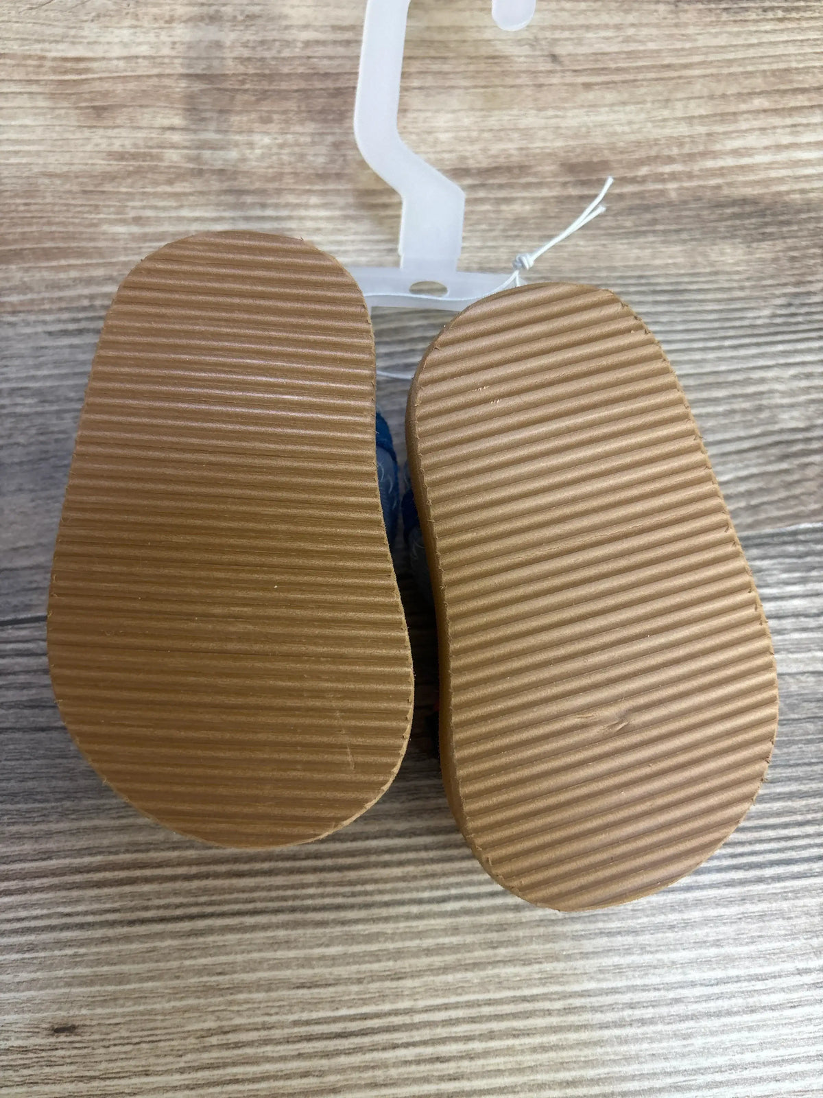 Bottom view of Wonder Nation Sports Slides Black sz 5c showcasing textured non-marking soles on a wood-grain surface
