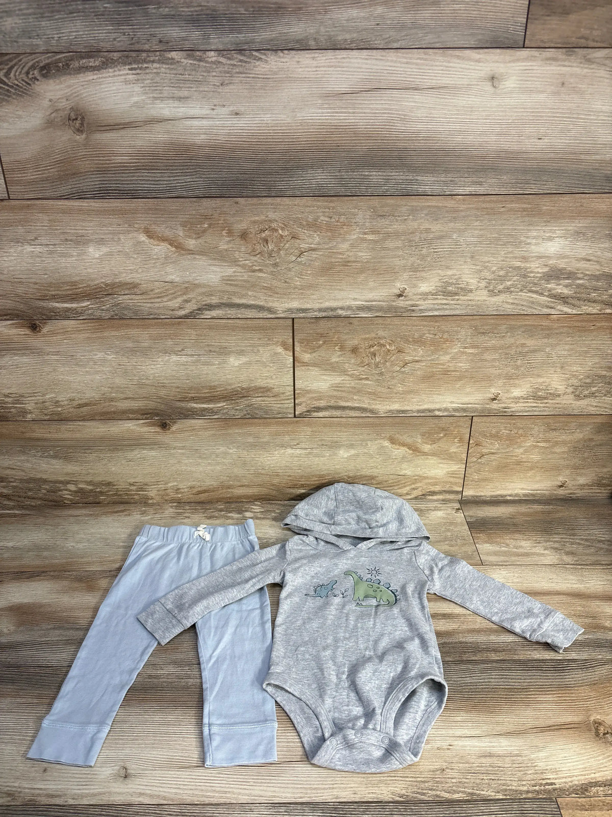 Overhead view of Carter’s 2-piece dinosaur hooded bodysuit set showcasing grey hood, dinosaur graphic, and matching pants
