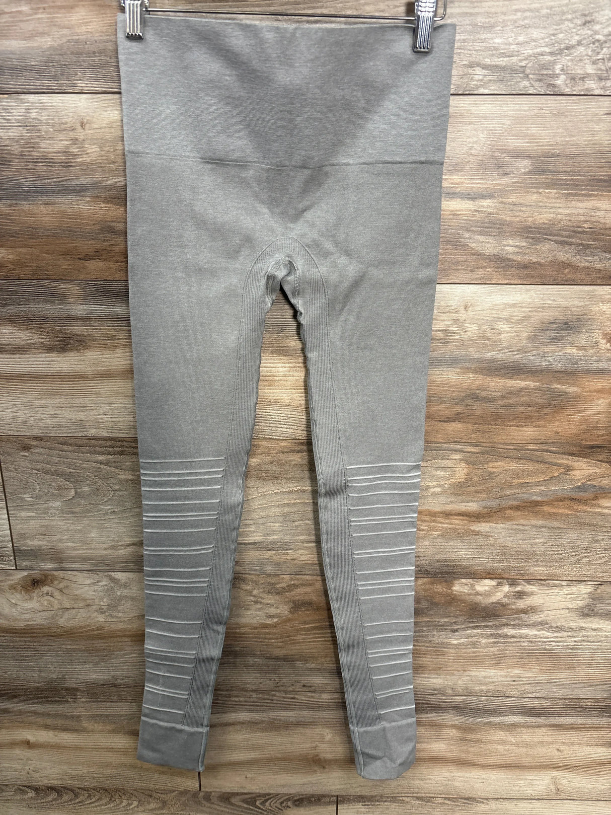 Flat lay Blanqi SportSupport hipster maternity leggings, gray; high-rise waistband and ribbed knee panels on wood background