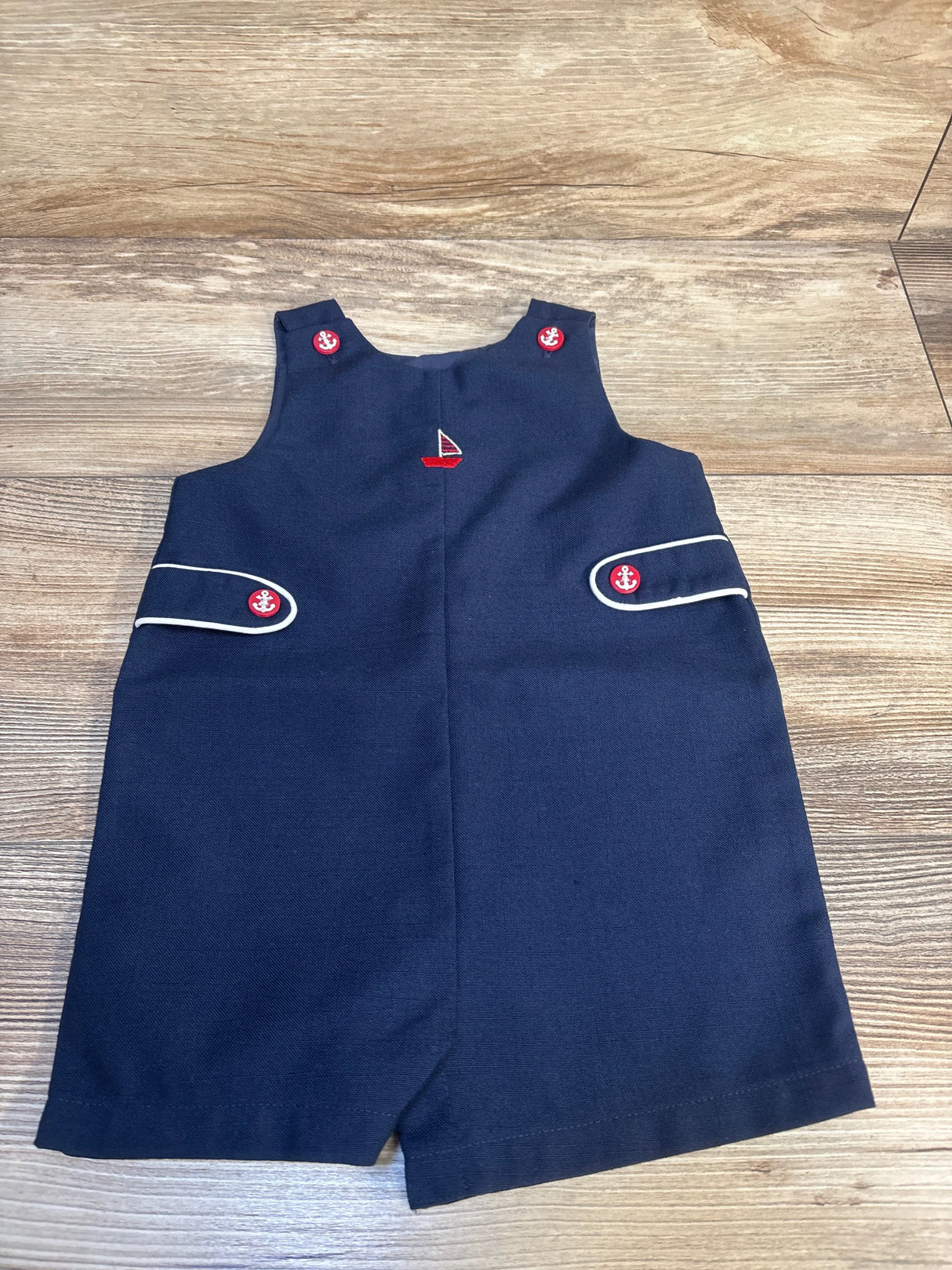 Navy blue toddler romper with nautical anchor buttons and red sailboat embroidery