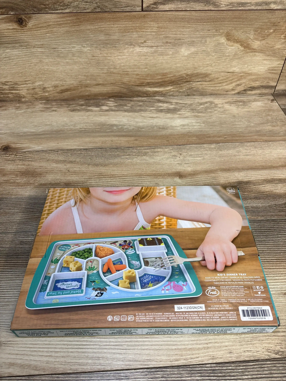 Top view of Fred Dinner Winner Pirate Dinner Tray packaging showcasing eight divided food compartments and a covered dessert section on a wooden table