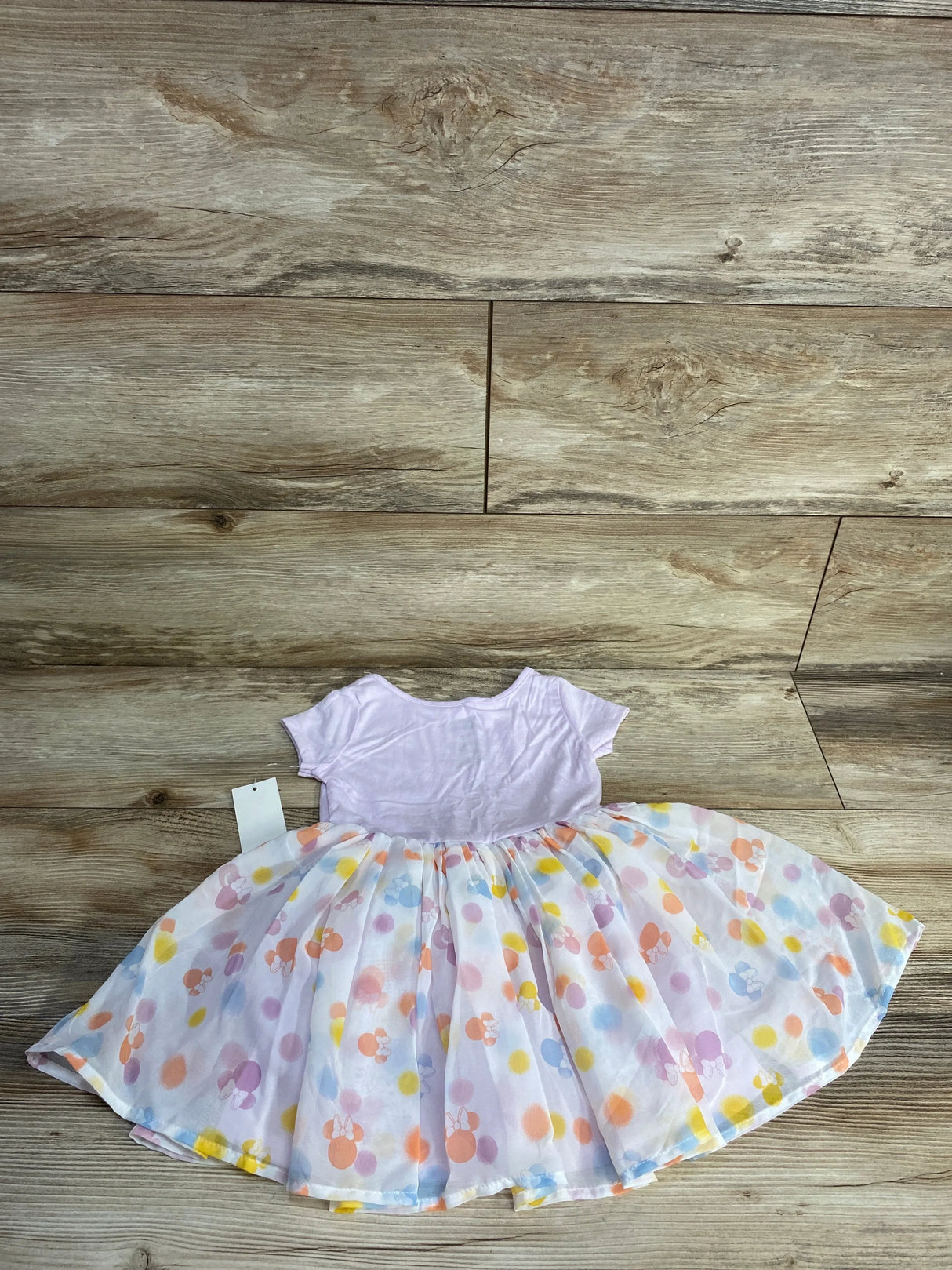 Pink short sleeve toddler dress with colorful polka dot tulle skirt on wood floor