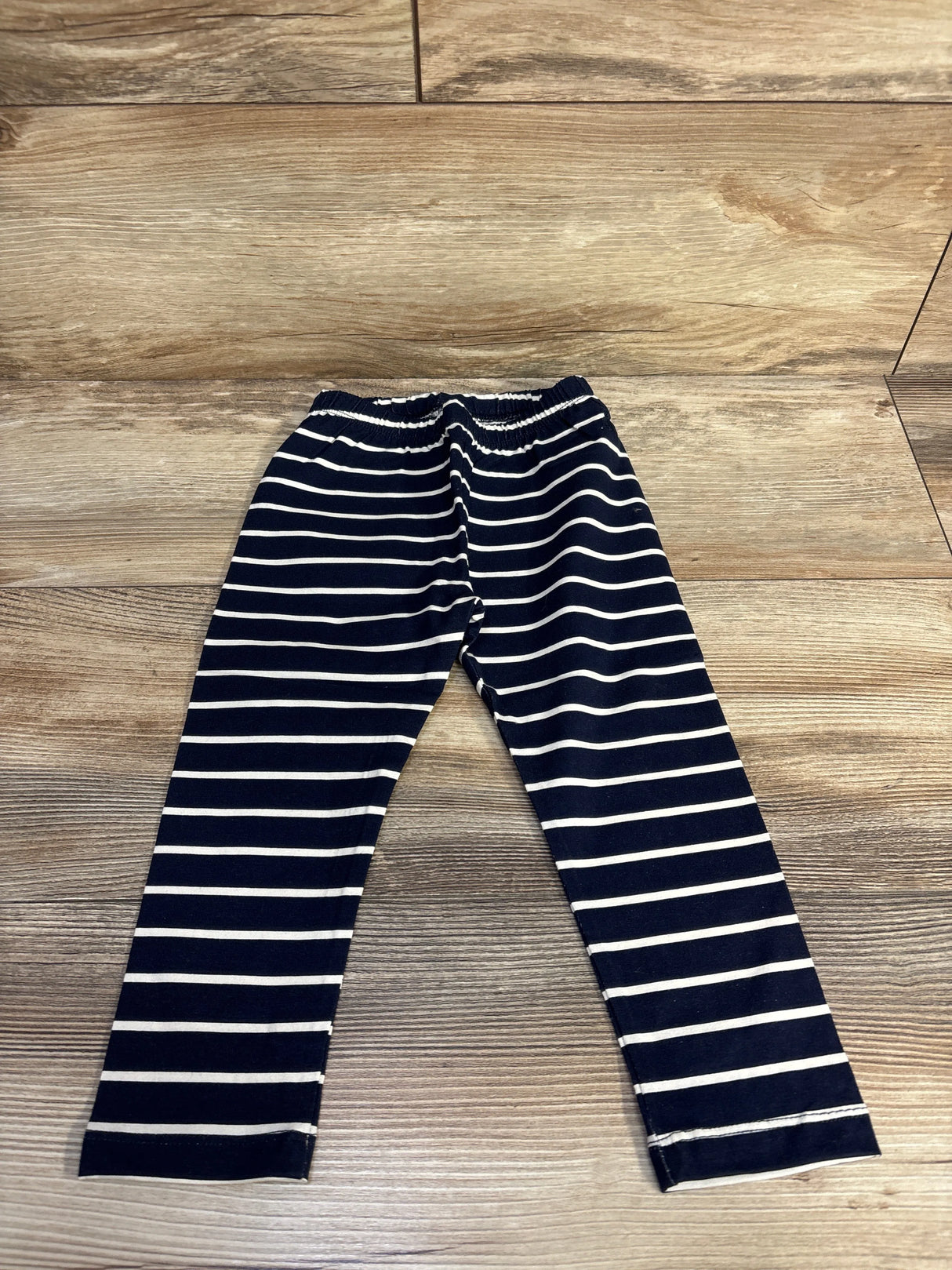 Navy blue and white striped kids leggings on wooden floor