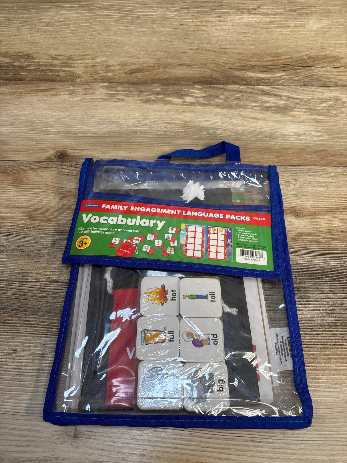 Vocabulary learning kit for kids ages 3+, featuring picture cards in a clear blue zip bag on wood floor.