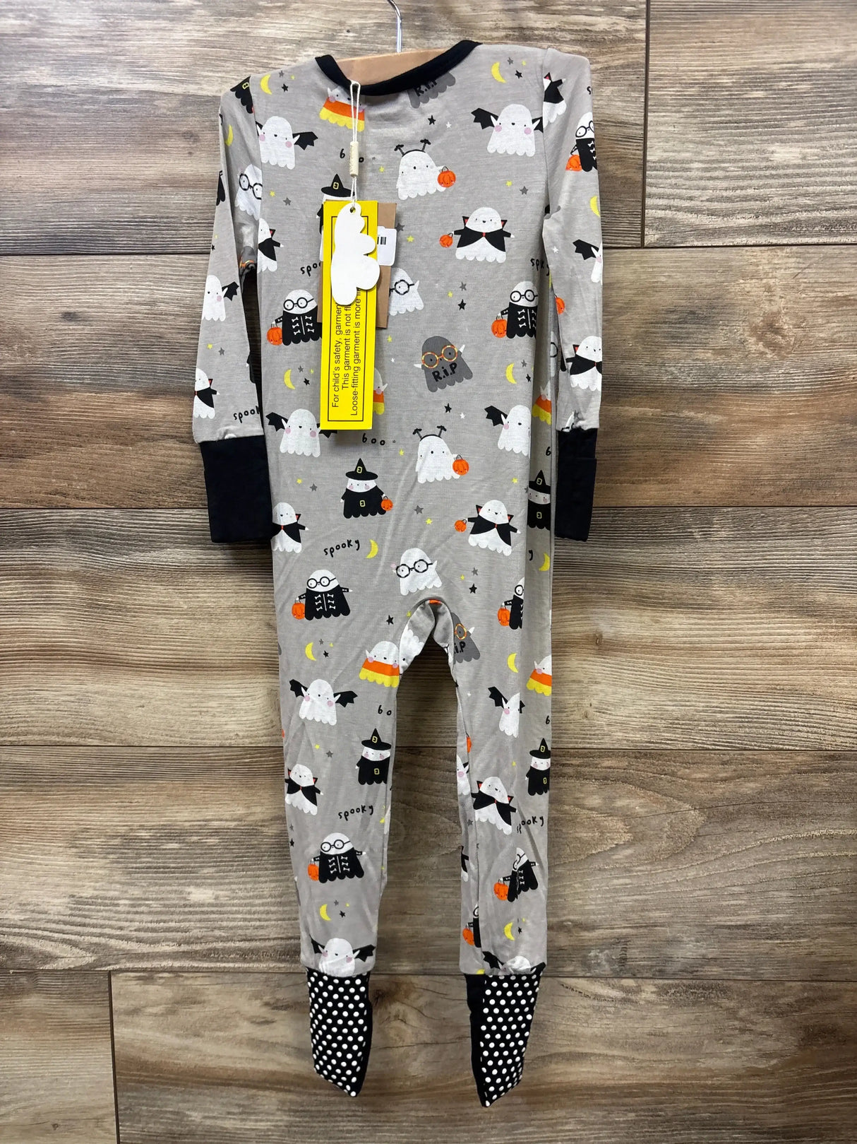 Gray Halloween baby onesie with ghosts, witches, pumpkins, and candy corn print, black cuffs, polka dot feet